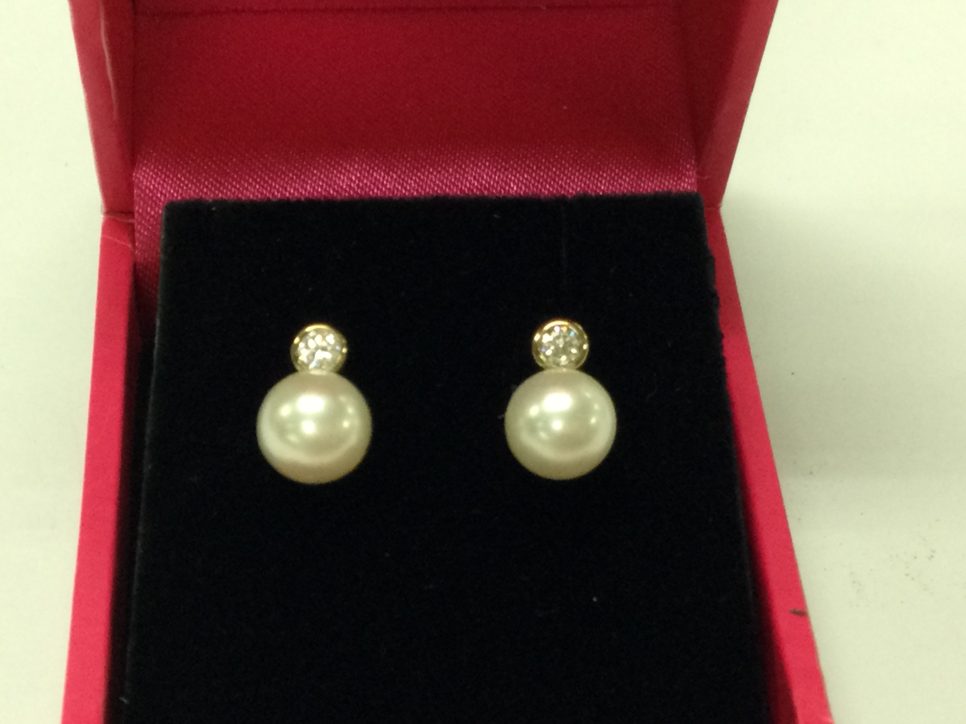 A pair of 9ct earring set with a pearl and diamond.