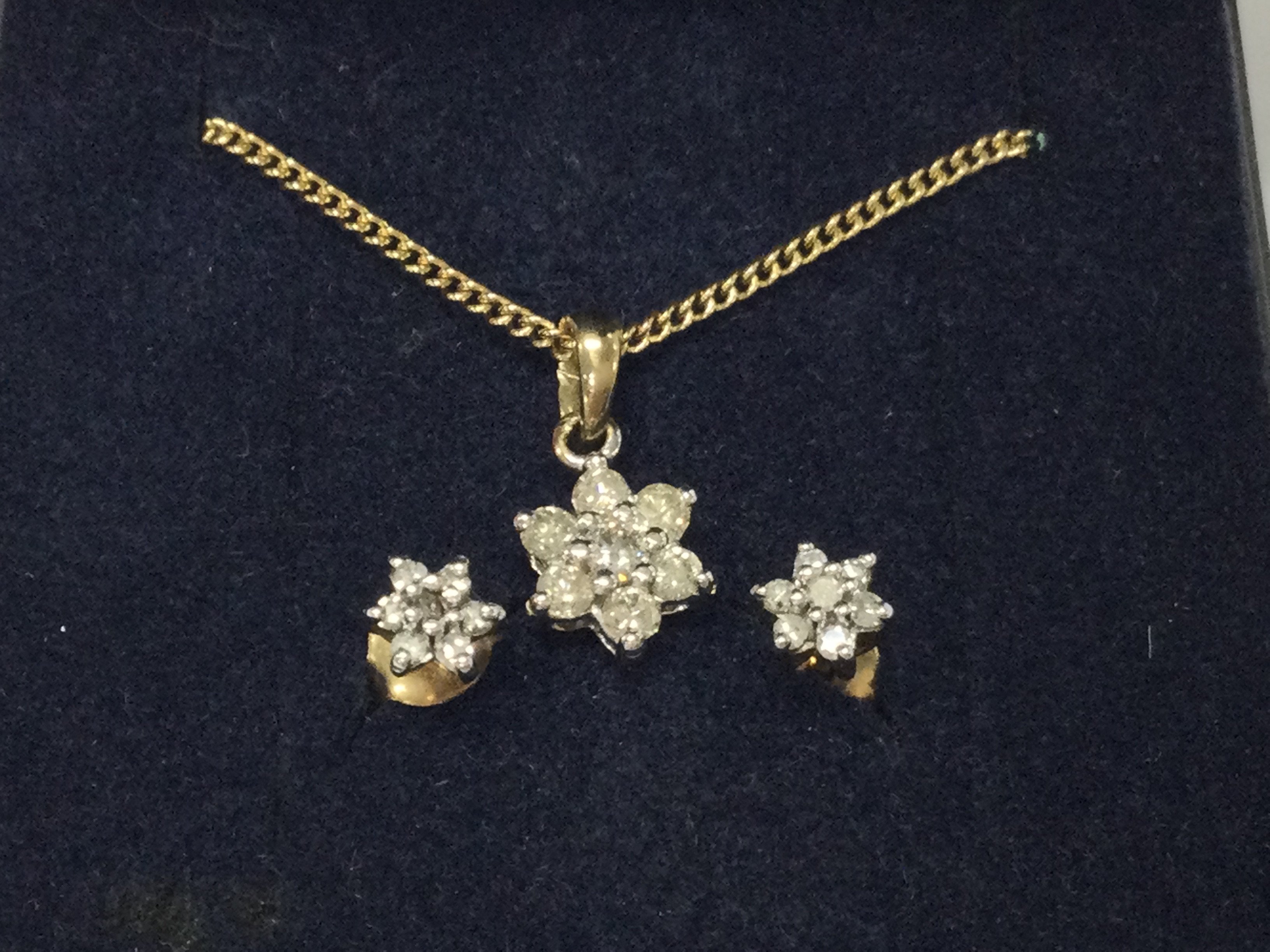 A 9ct gold diamond pendant on 9ct chain with matching earrings.