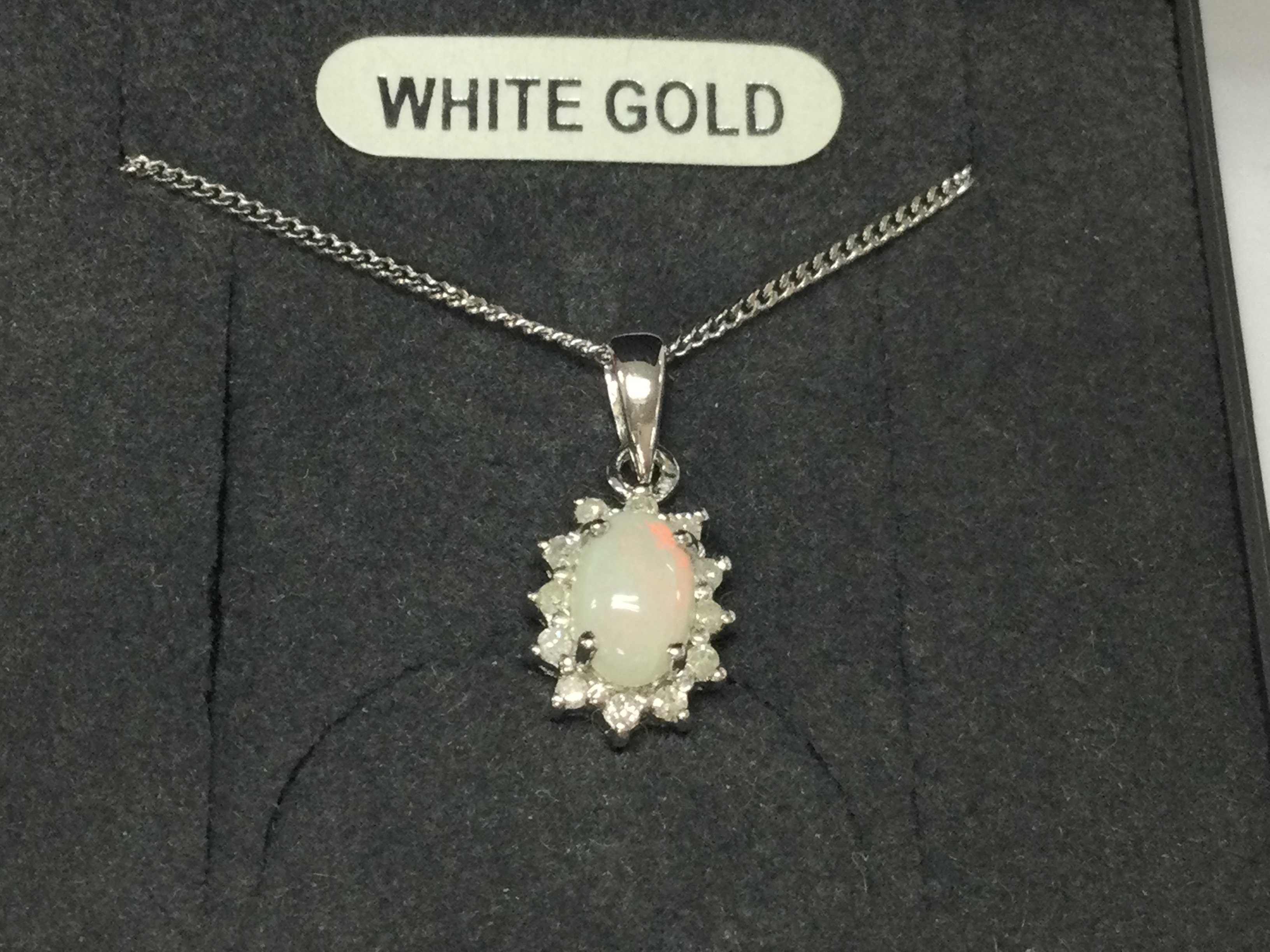 A 9ct white gold chain with attached diamond and opal pendant.