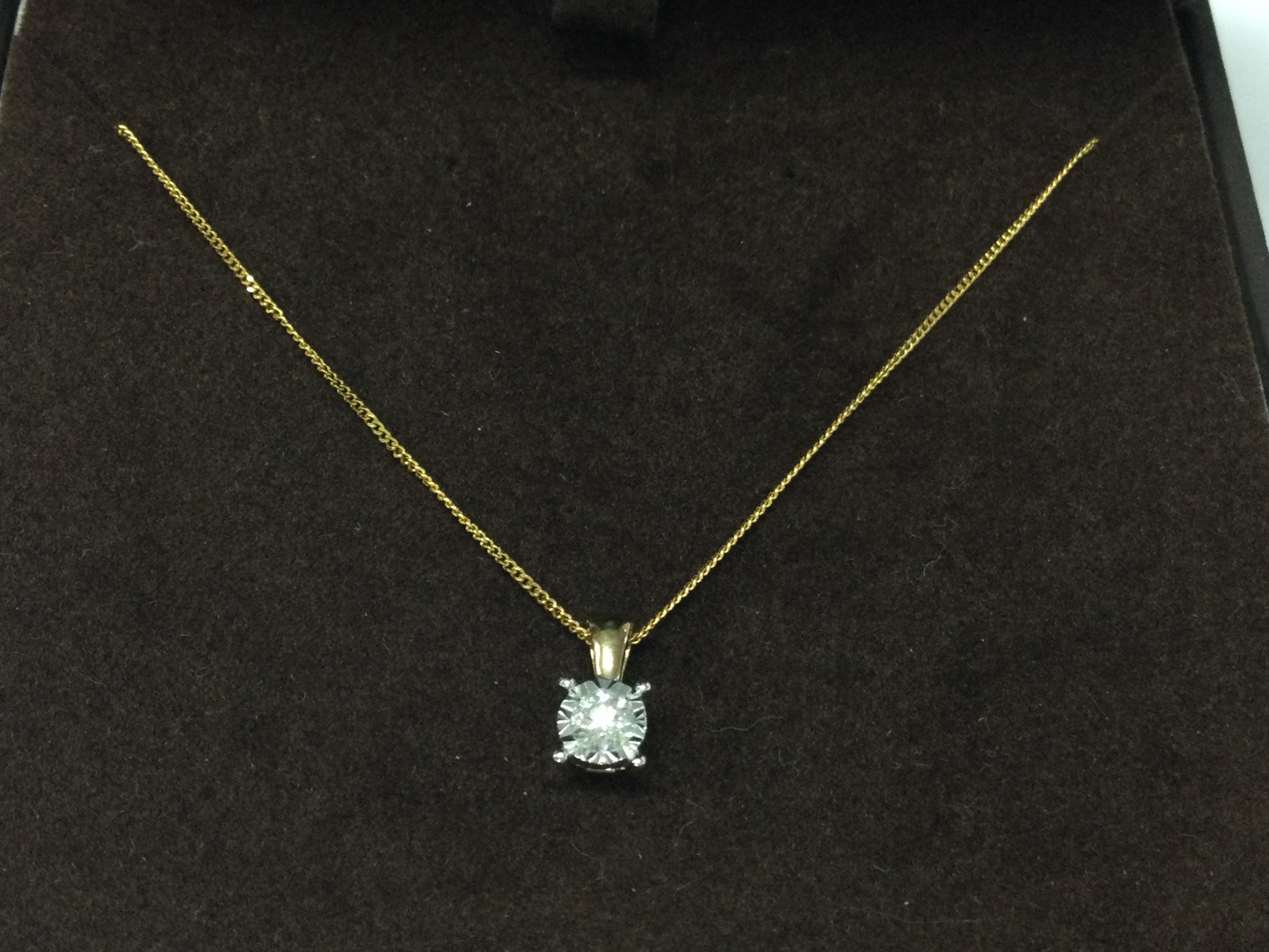 A 9ct gold chain with diamond solitaire pendant.