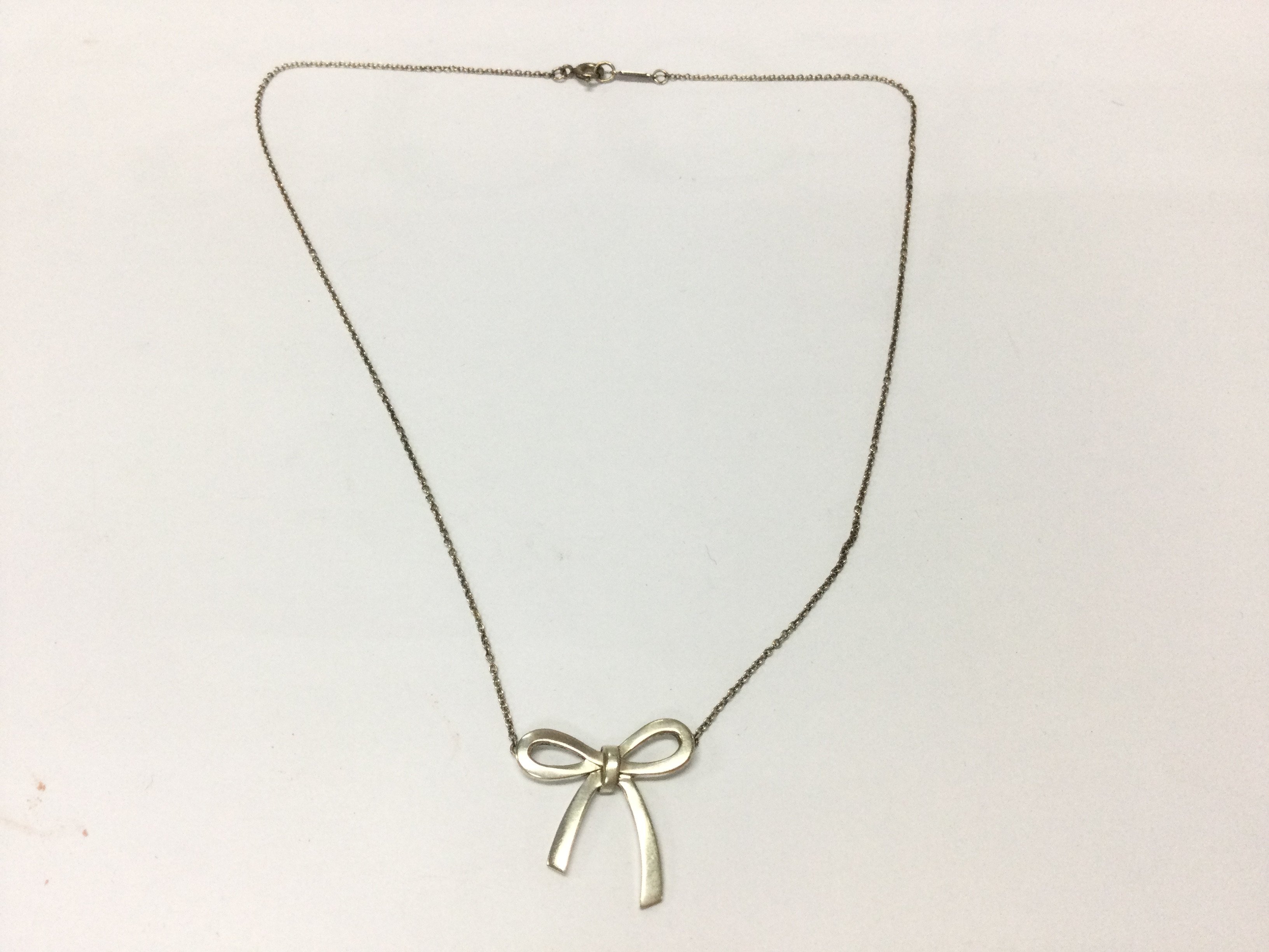 A boxed silver Tiffany and Co bow necklace.