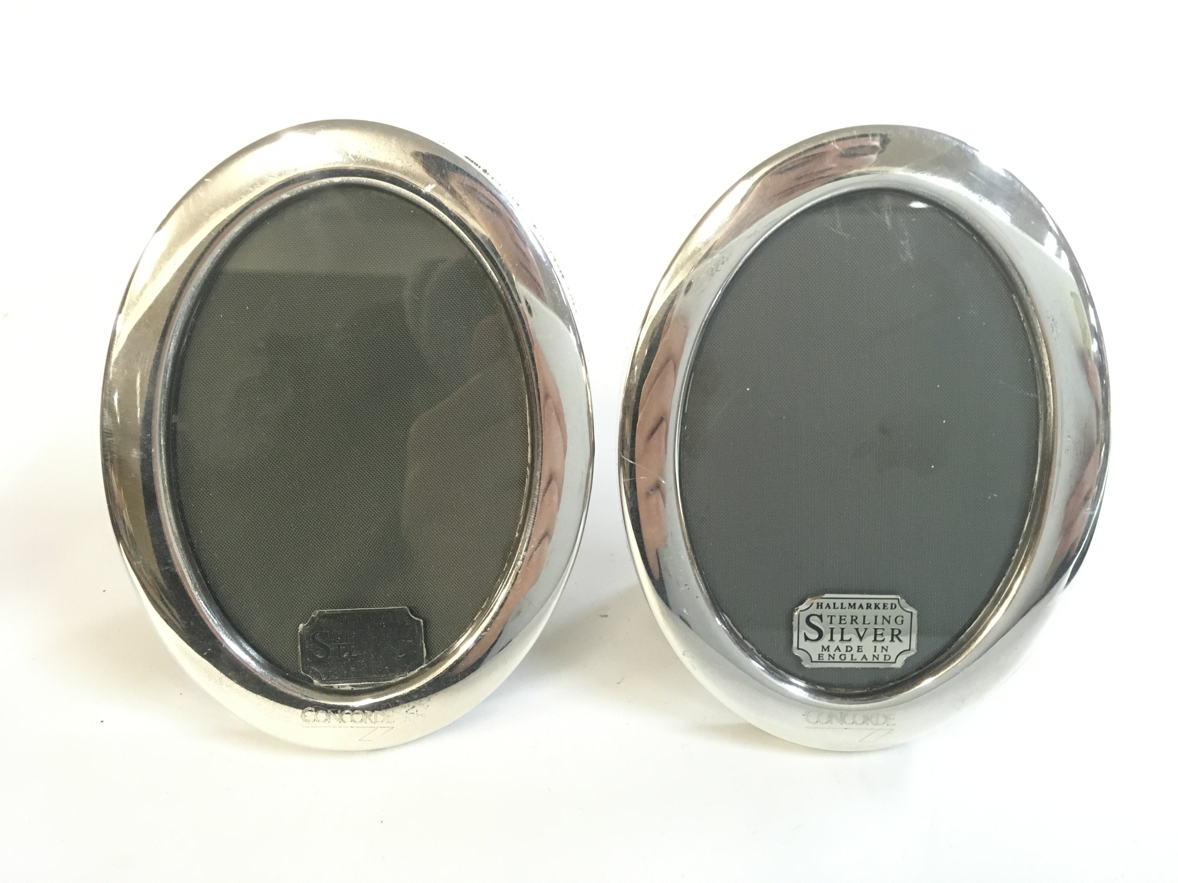 A pair of silver oval Concorde frames . Postage category A