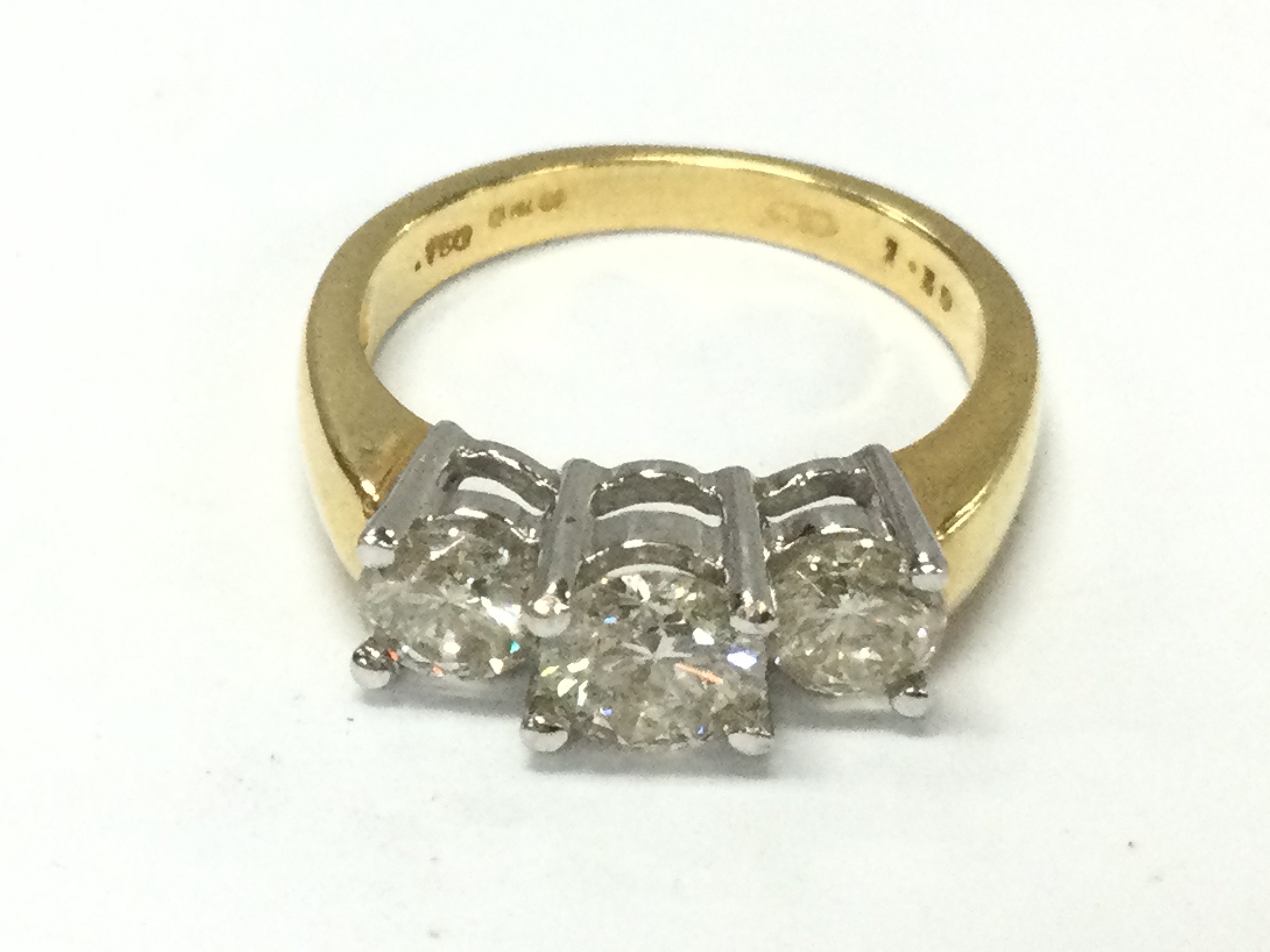 An 18ct gold three stone diamond ring set with approximately 1.5ct total and size M 1/2 and 5.1g