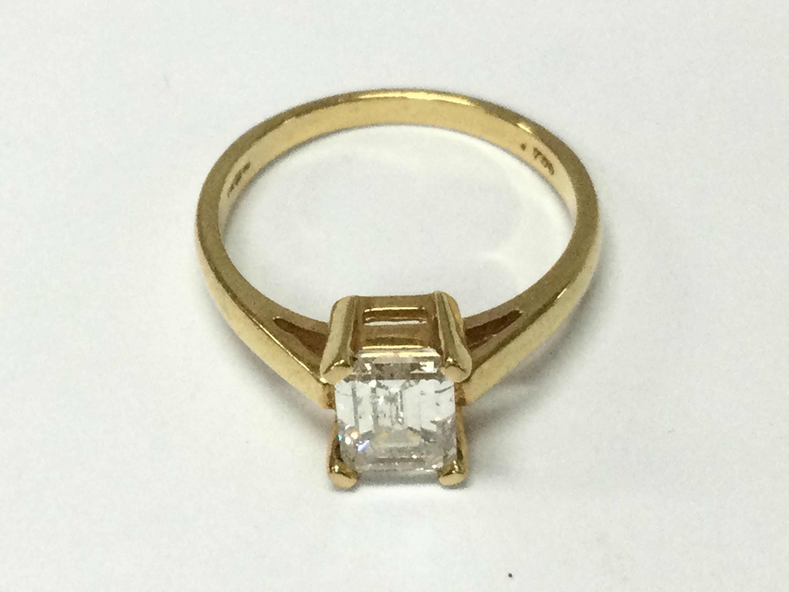 An 18ct yellow gold emerald cut diamond ring. Size N and 3.62g