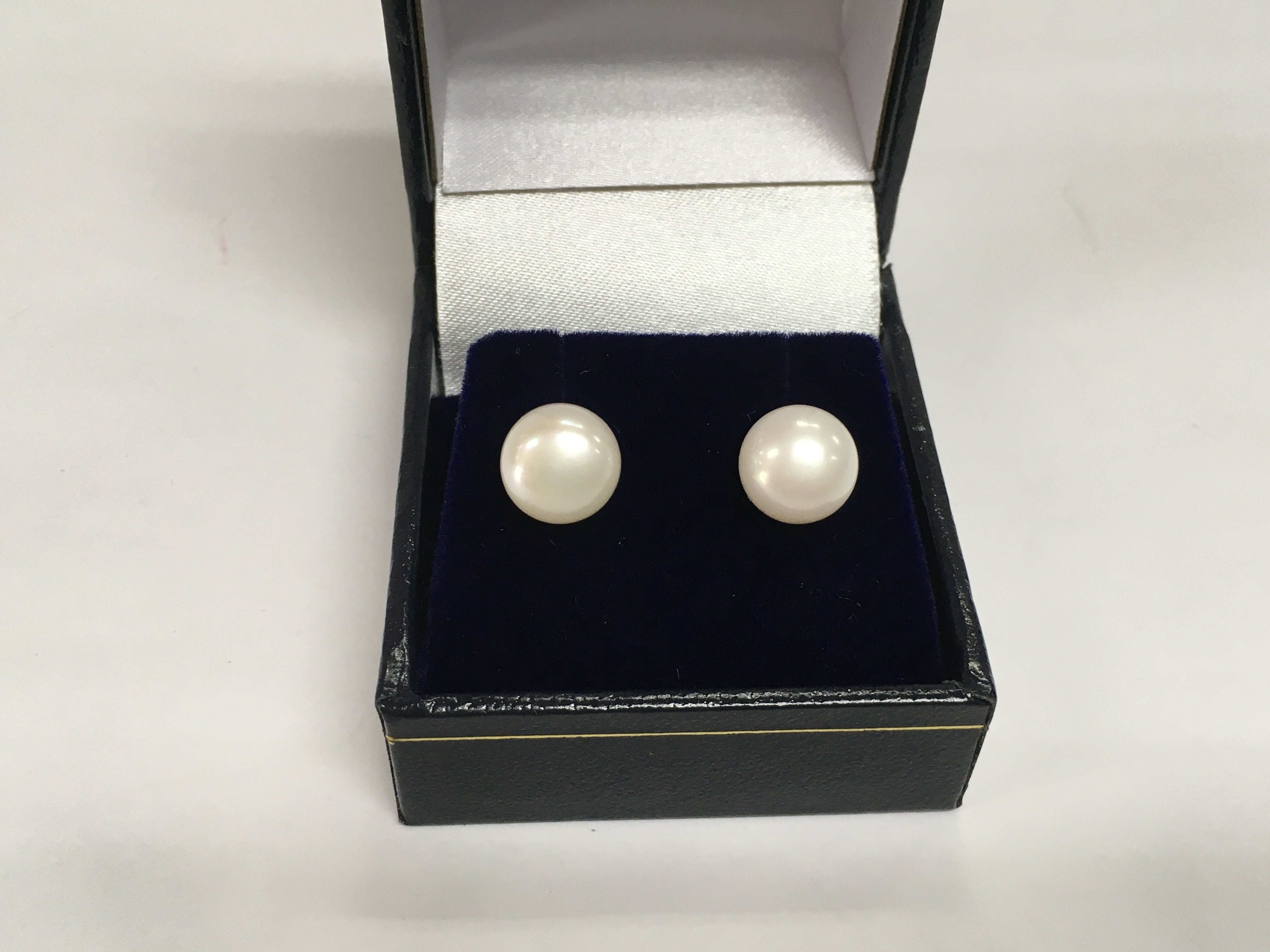 A pair of 9ct yellow gold oblate spheroid white cultured pearl studs. Shipping category A.