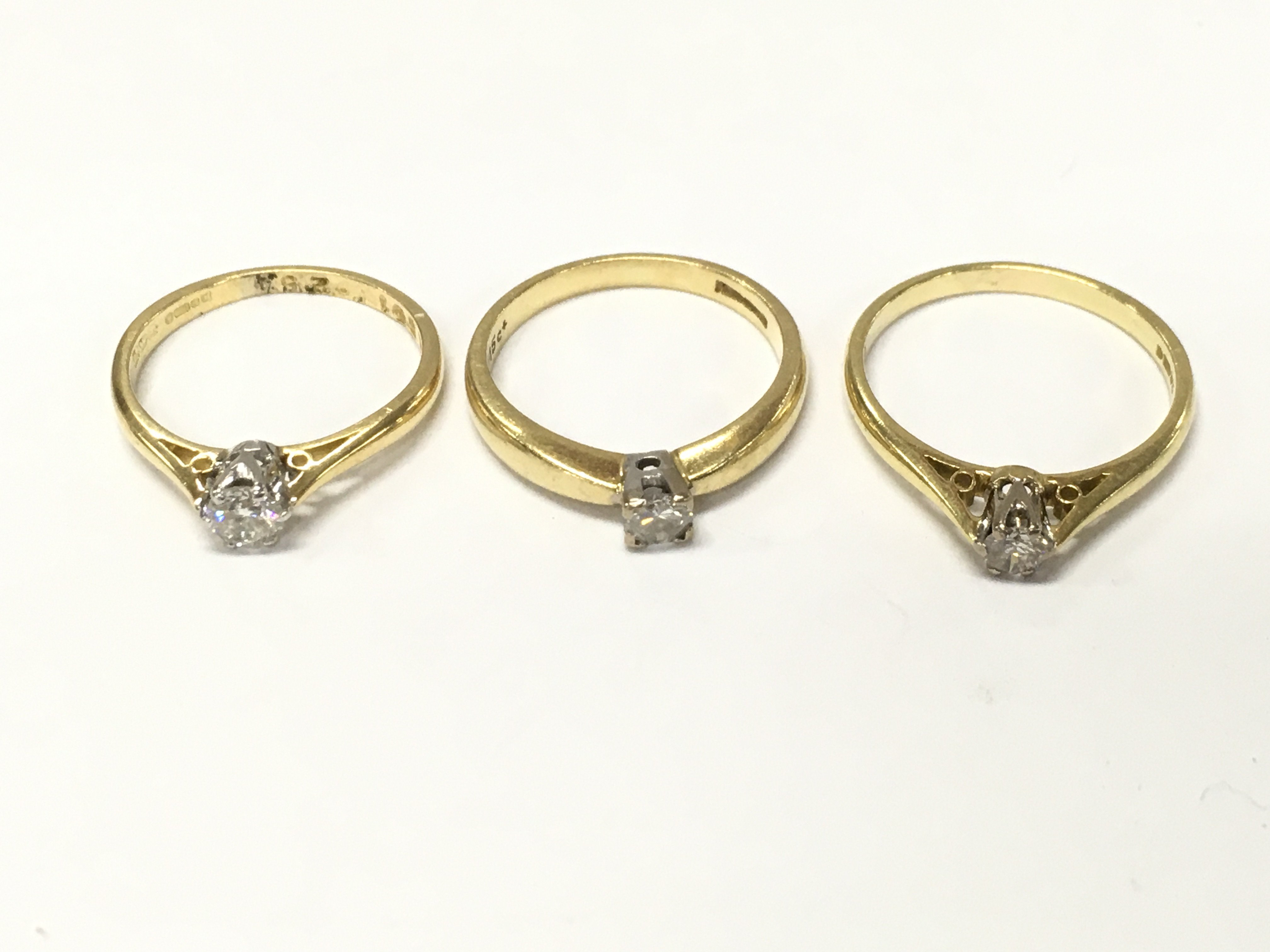 Three 18ct gold diamond solitaire rings. J K and M approximately 7g