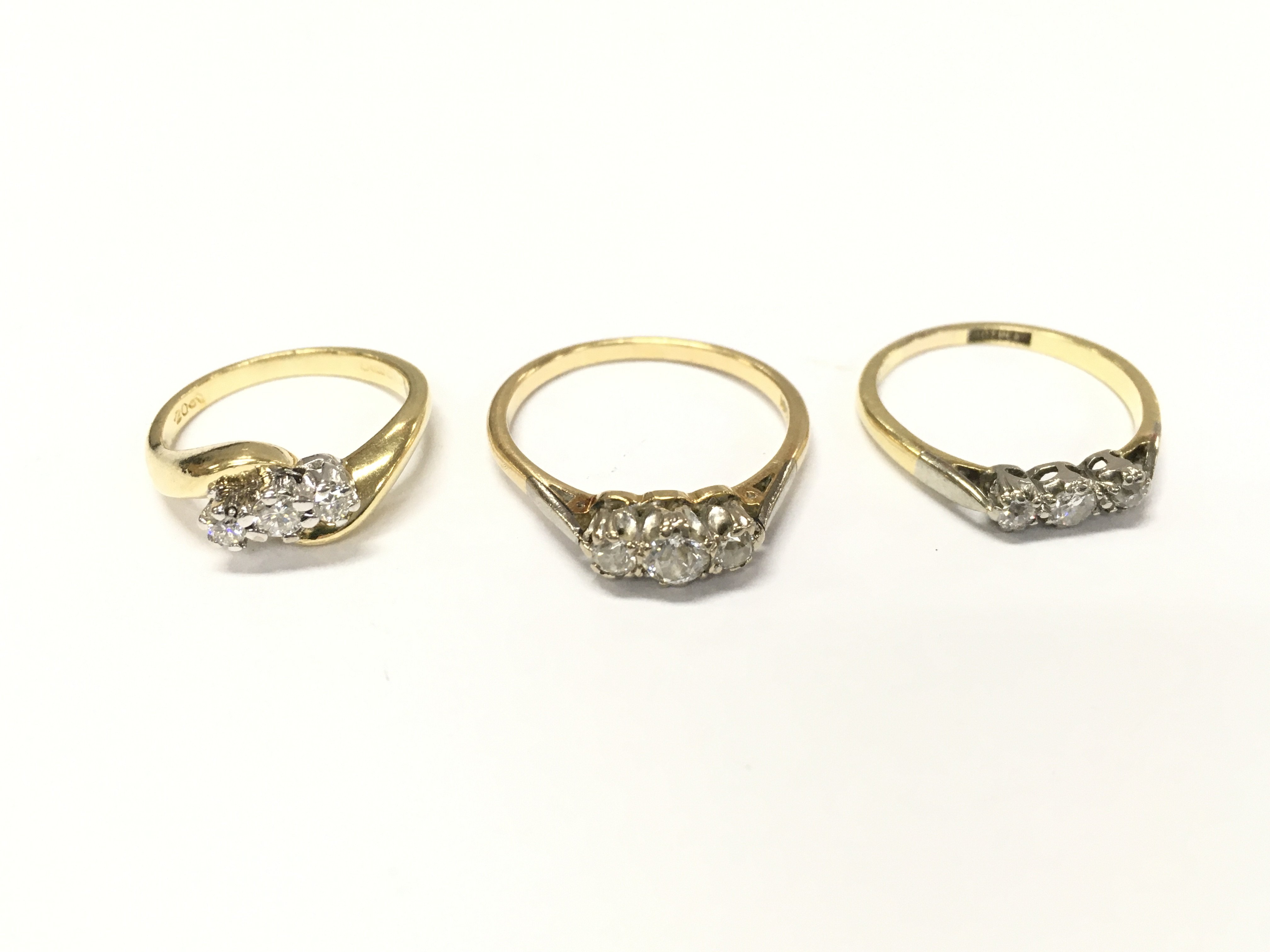 Three 18ct gold diamond three stone rings. J N and Q and approximately 9.8g