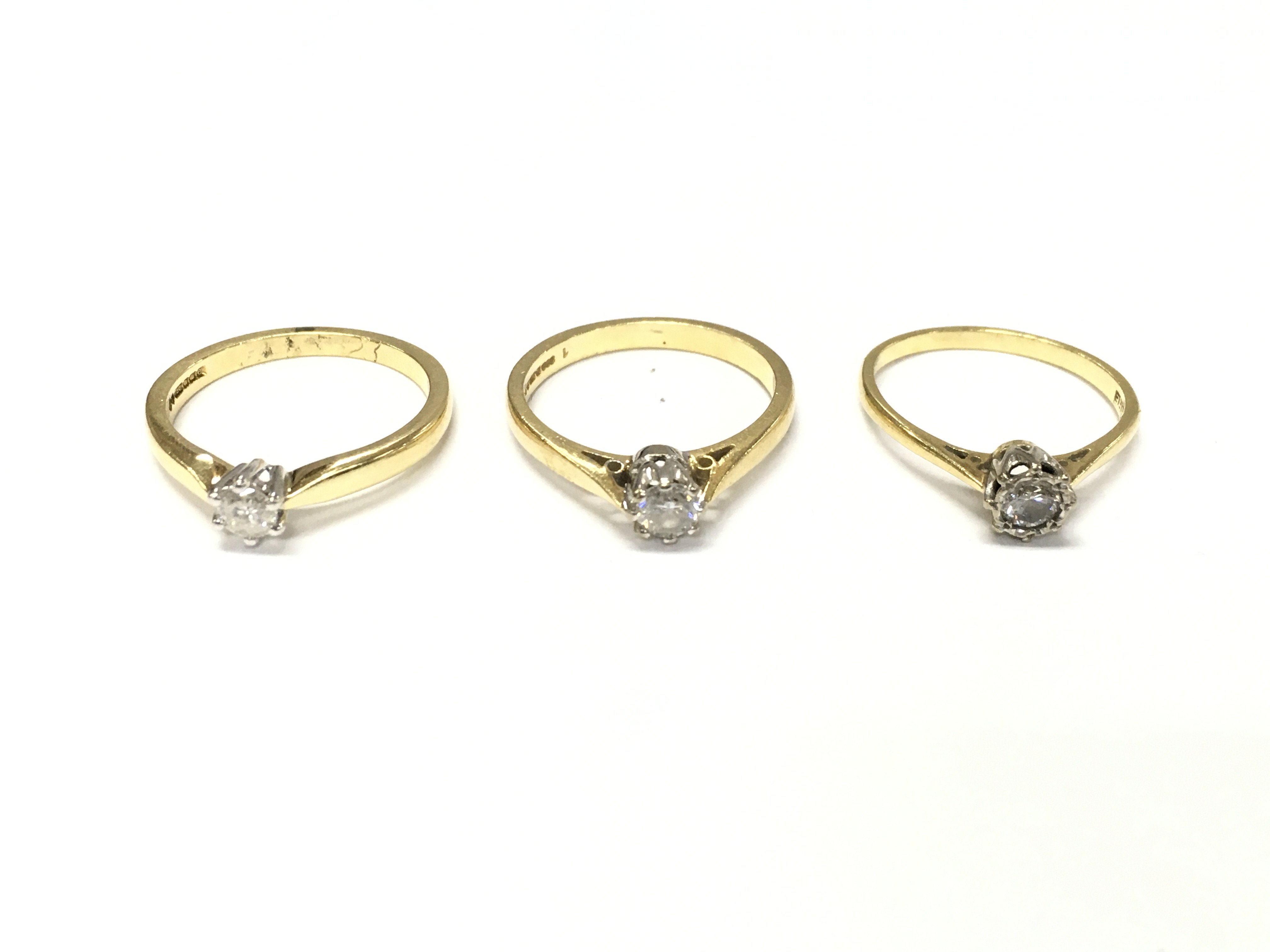 Three 18ct gold diamond solitaire rings. L 1/2 M 1/2 N approximately 8.4g