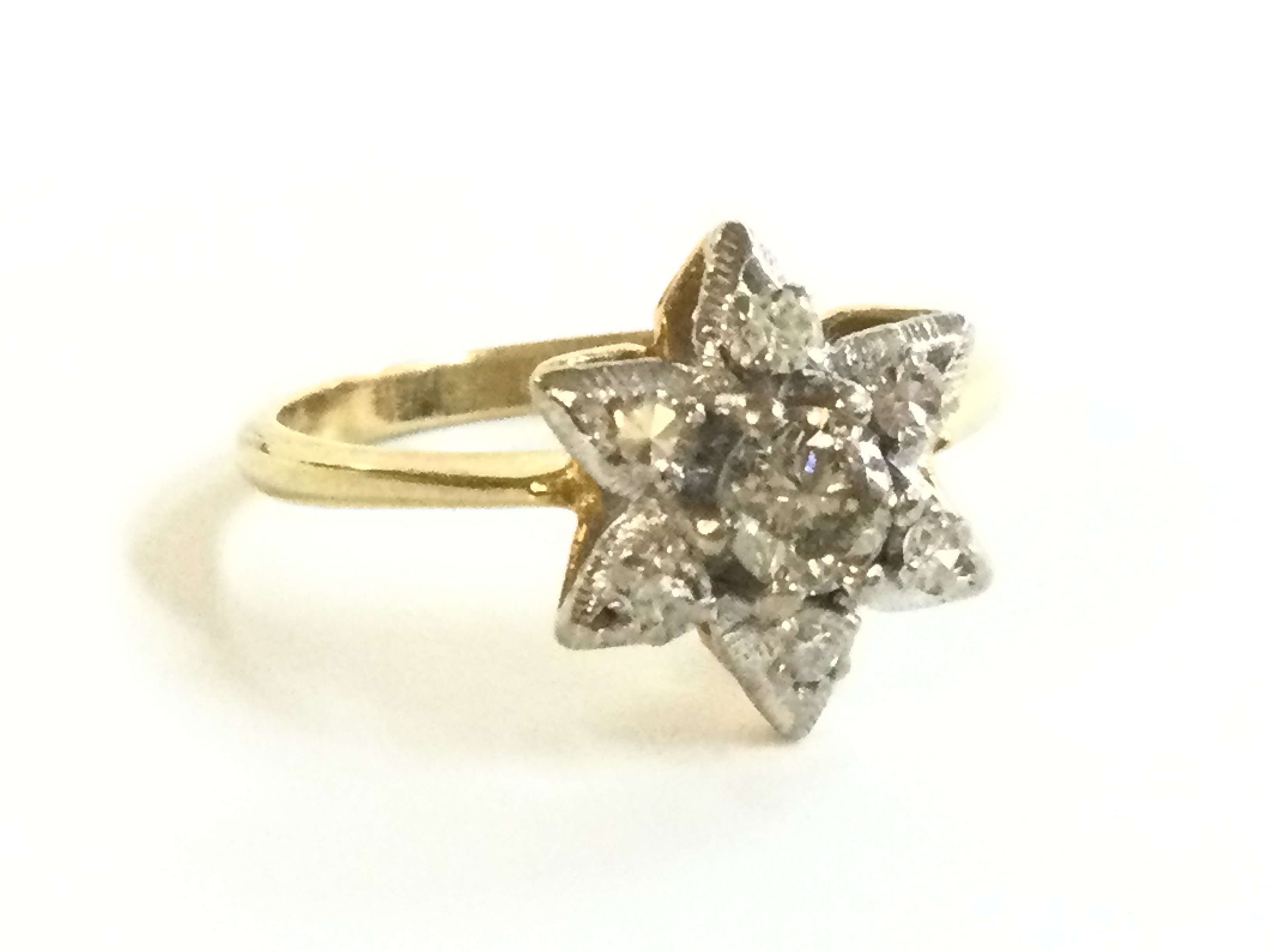 An 18ct gold diamond cluster star ring , size Q. 4g total weight. Postage category A