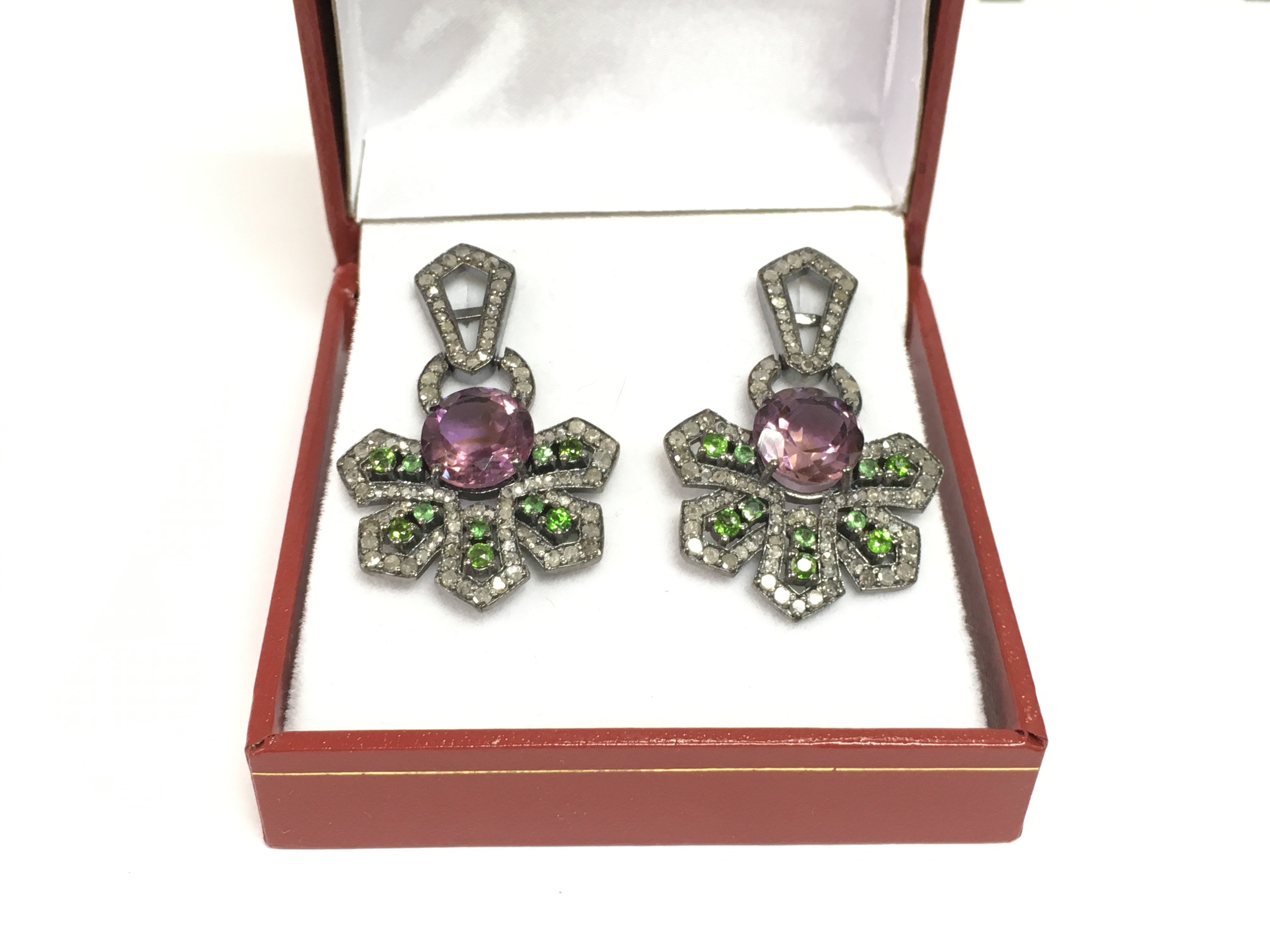 A pair of stylised silver and black rhodium drop earrings set with large round amethysts, chrome diopsides and diamonds. Amethysts approx 5.00ct, diopside approx 1.00ct, diamonds approx 1.85ct. Shipping category A.