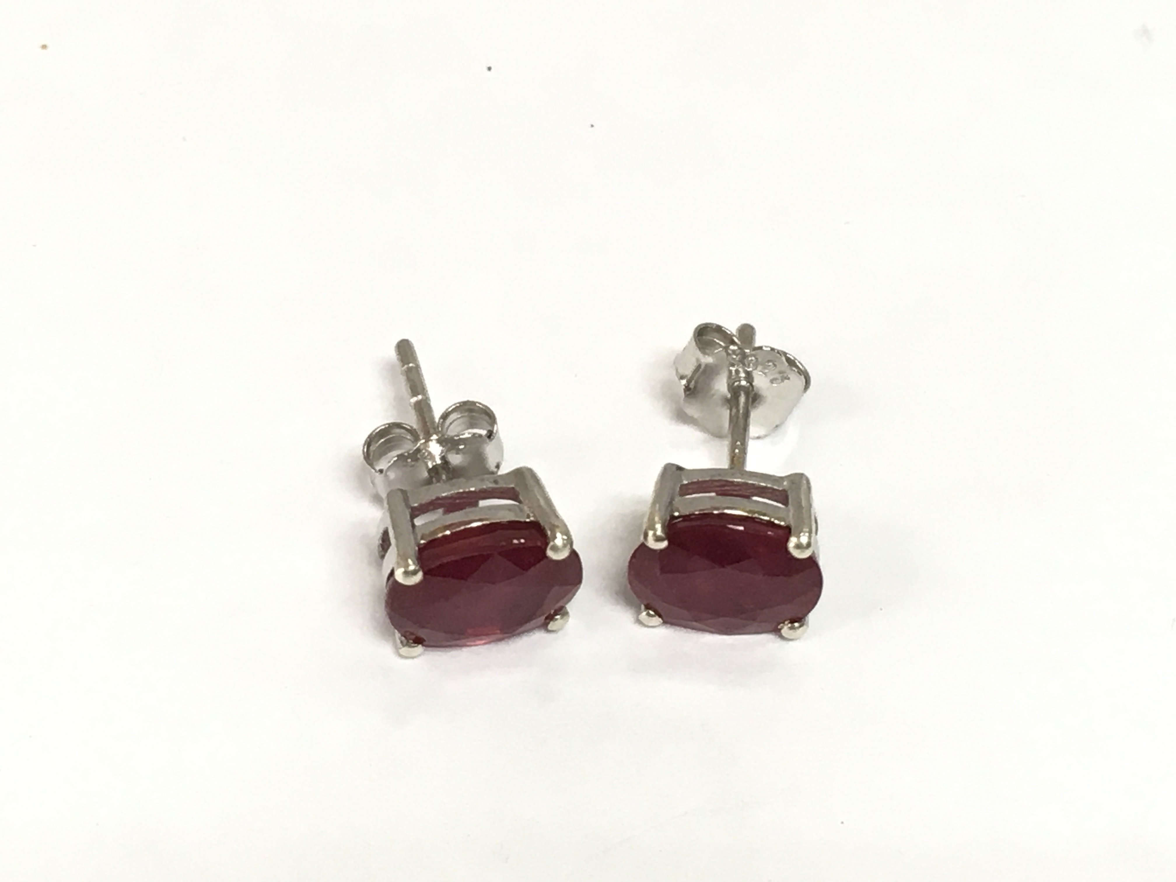 A pair of treated ruby studs in silver. Shipping category A.