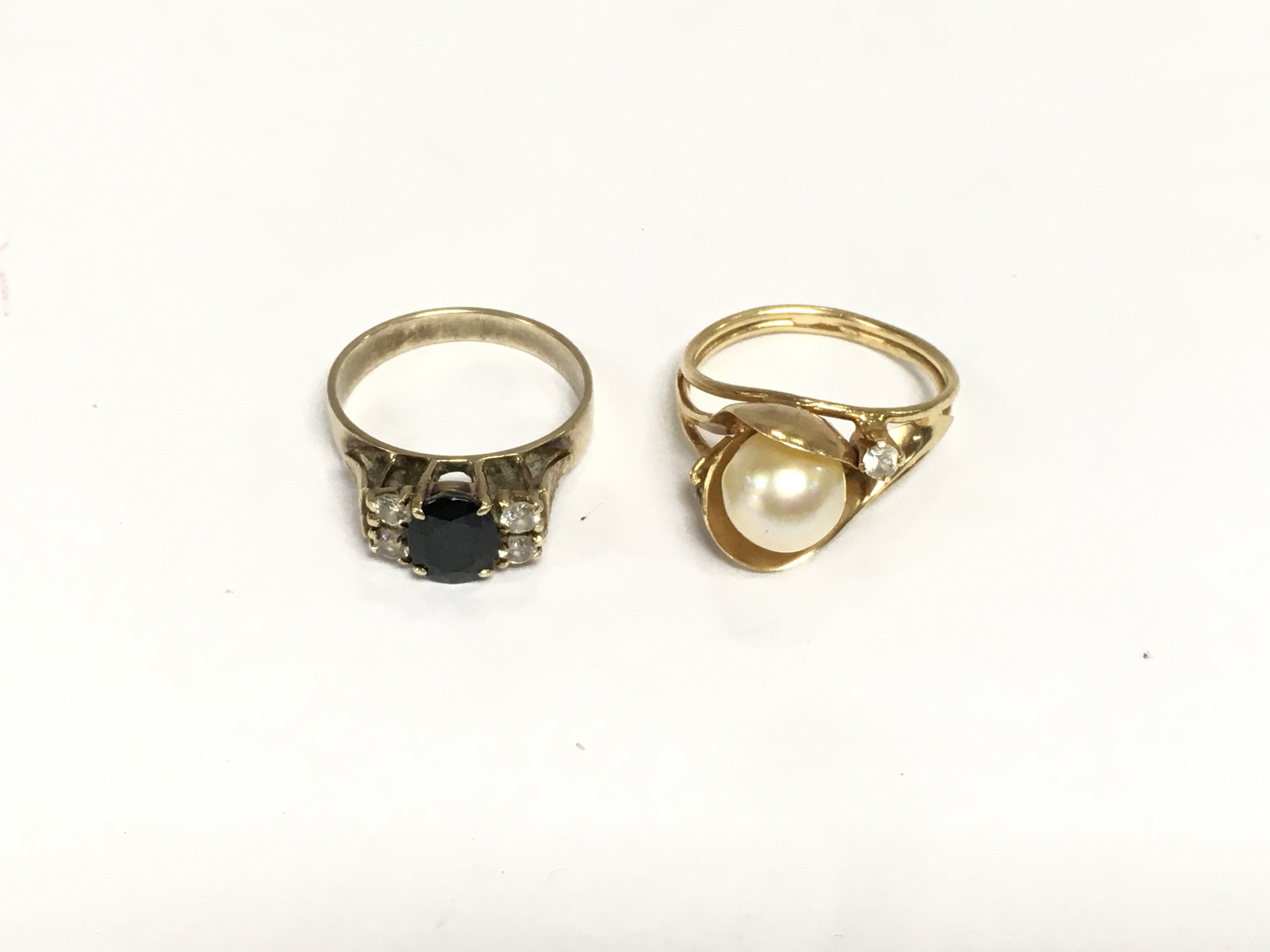 Two unmarked yellow metal stone set rings, approx total weight 7.6g. Shipping category A.