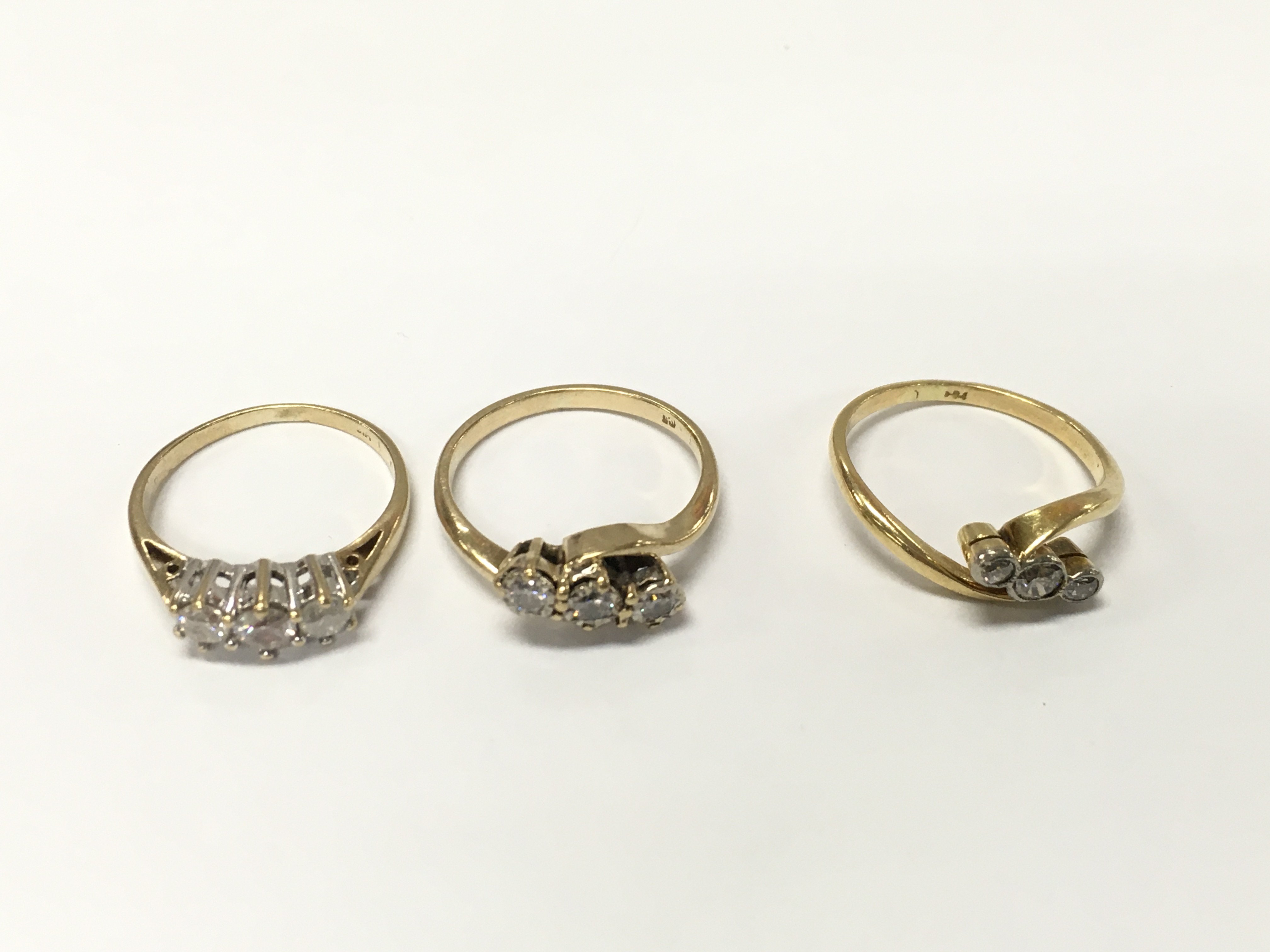 Three unmarked yellow metal three diamond rings. Sizes K and approximately 6.3g
