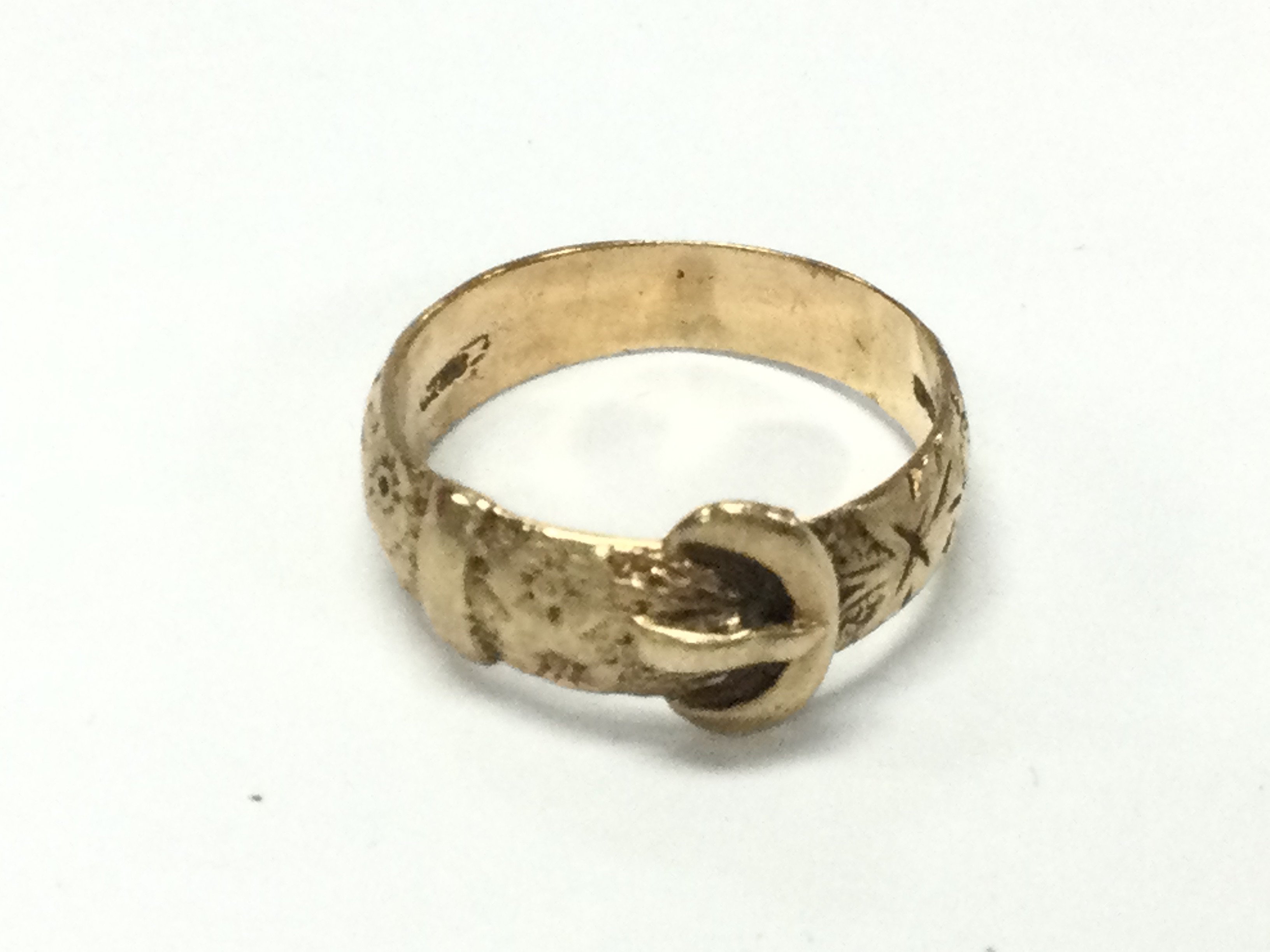 A 9ct gold buckle ring with floral engraving. 5.43g and size W