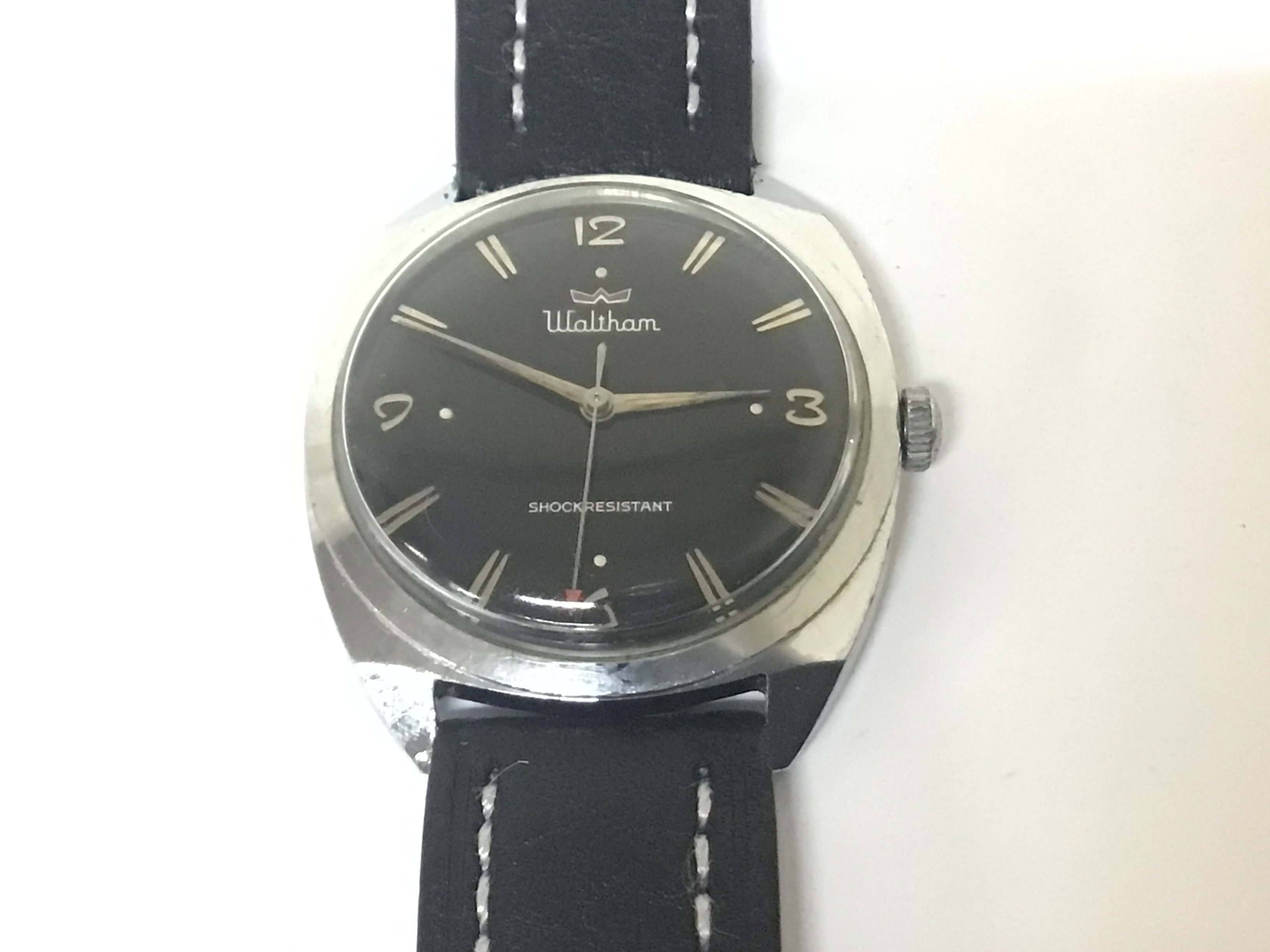 A vintage manual wind Gents Waltham watch with a black dial chrome plated case in very good condition seen working.