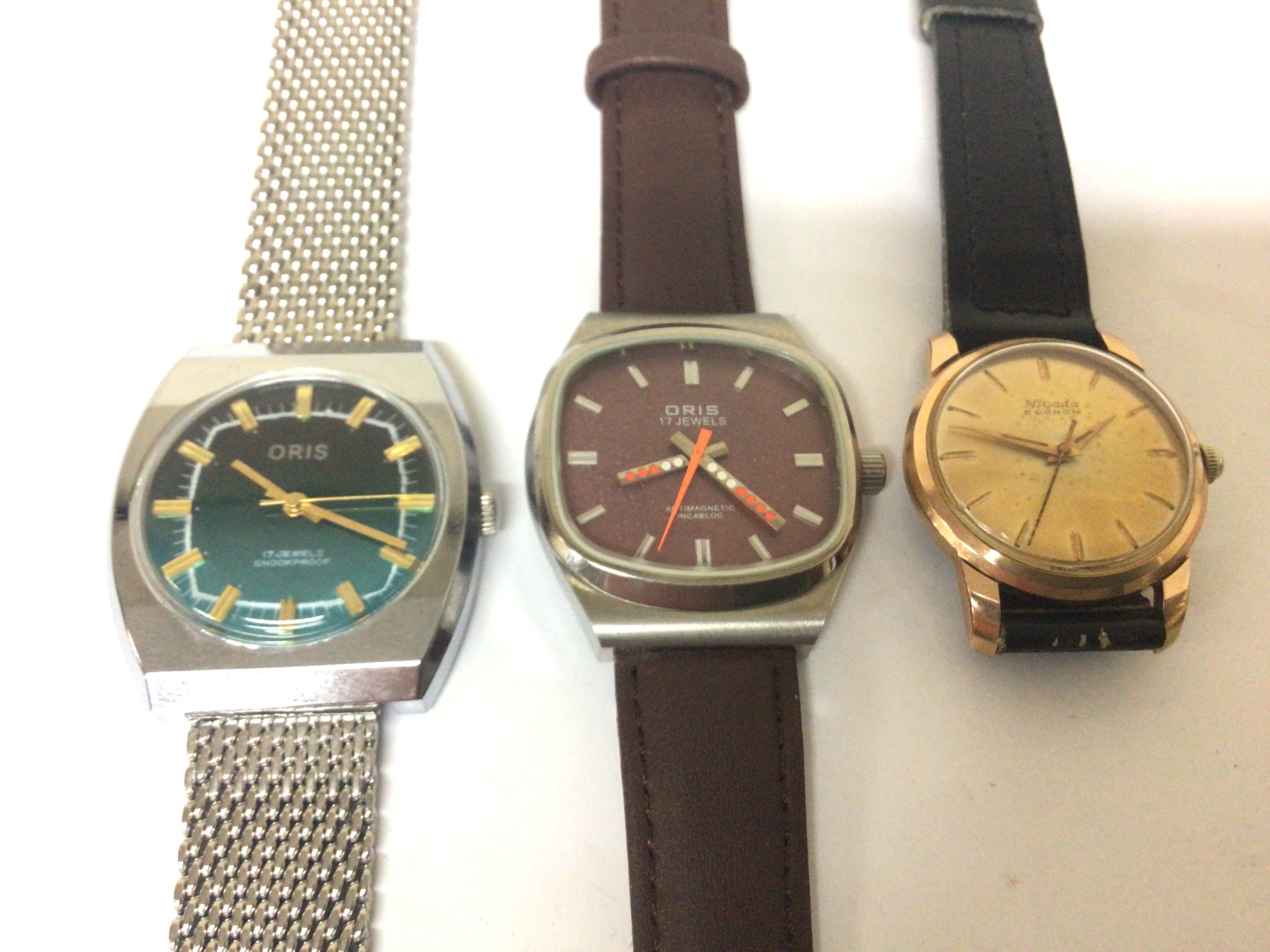 A vintage Oris wrist watch with orange second hand seen working one other Oris watch with a Chrome strap and a Nivada watch (3)