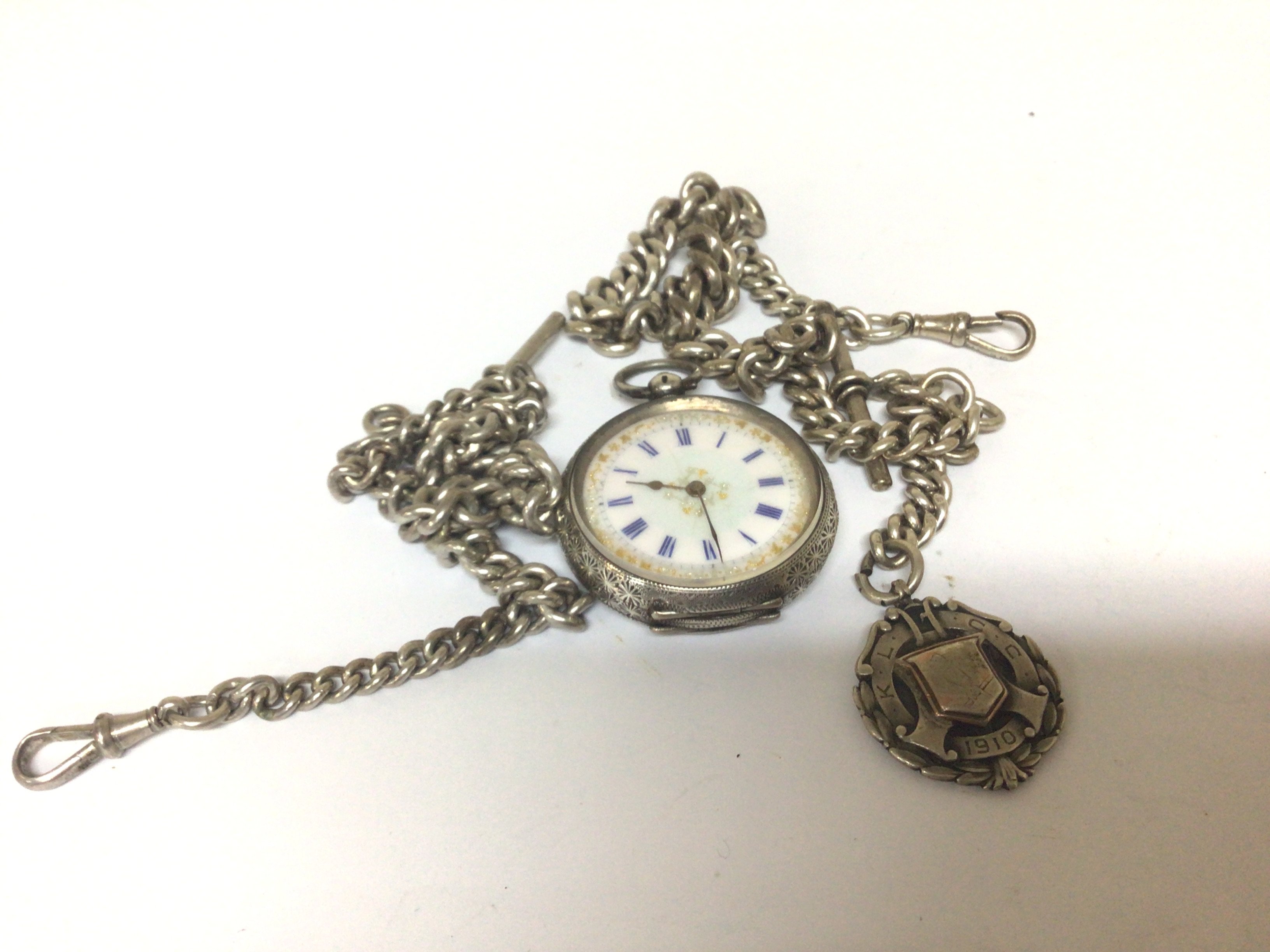 A Swiss silver Key wind pocket watch and two silver chains.