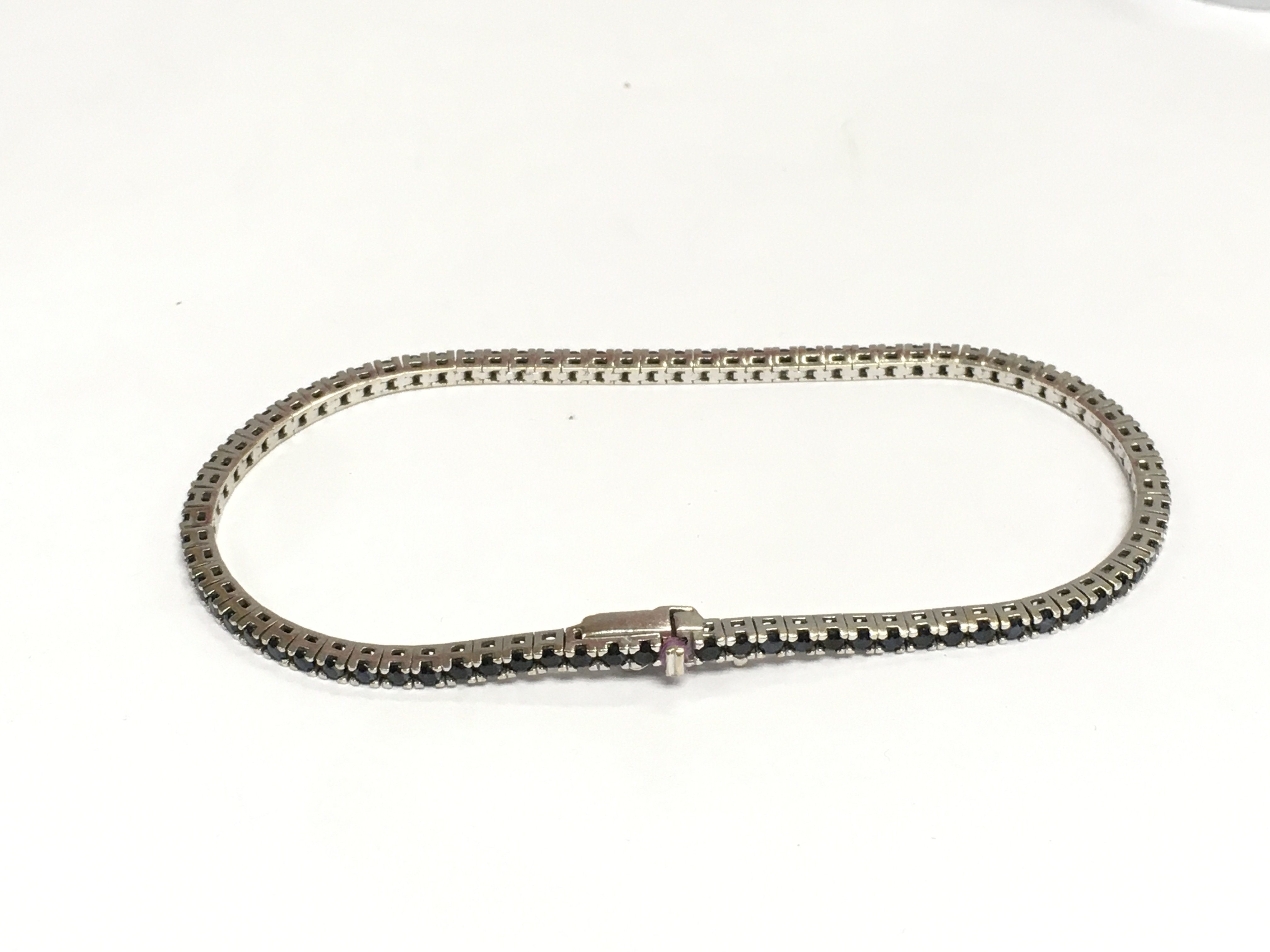 An 18ct white gold line bracelet set with sapphires, approx 7.4g. Shipping category A.