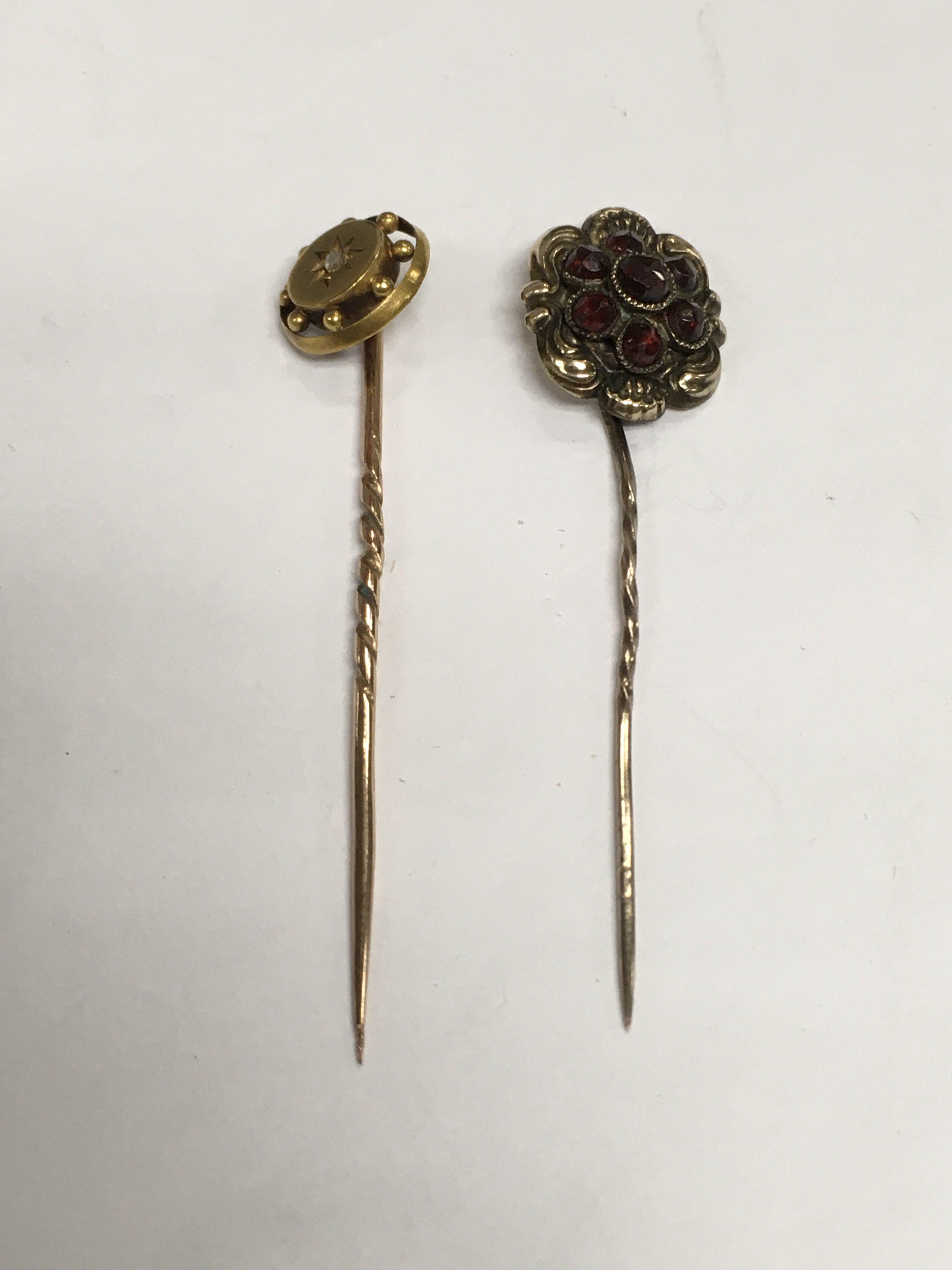Two gold stick pins, one marked 15ct, approx total weight 2.6g. Shipping category A.