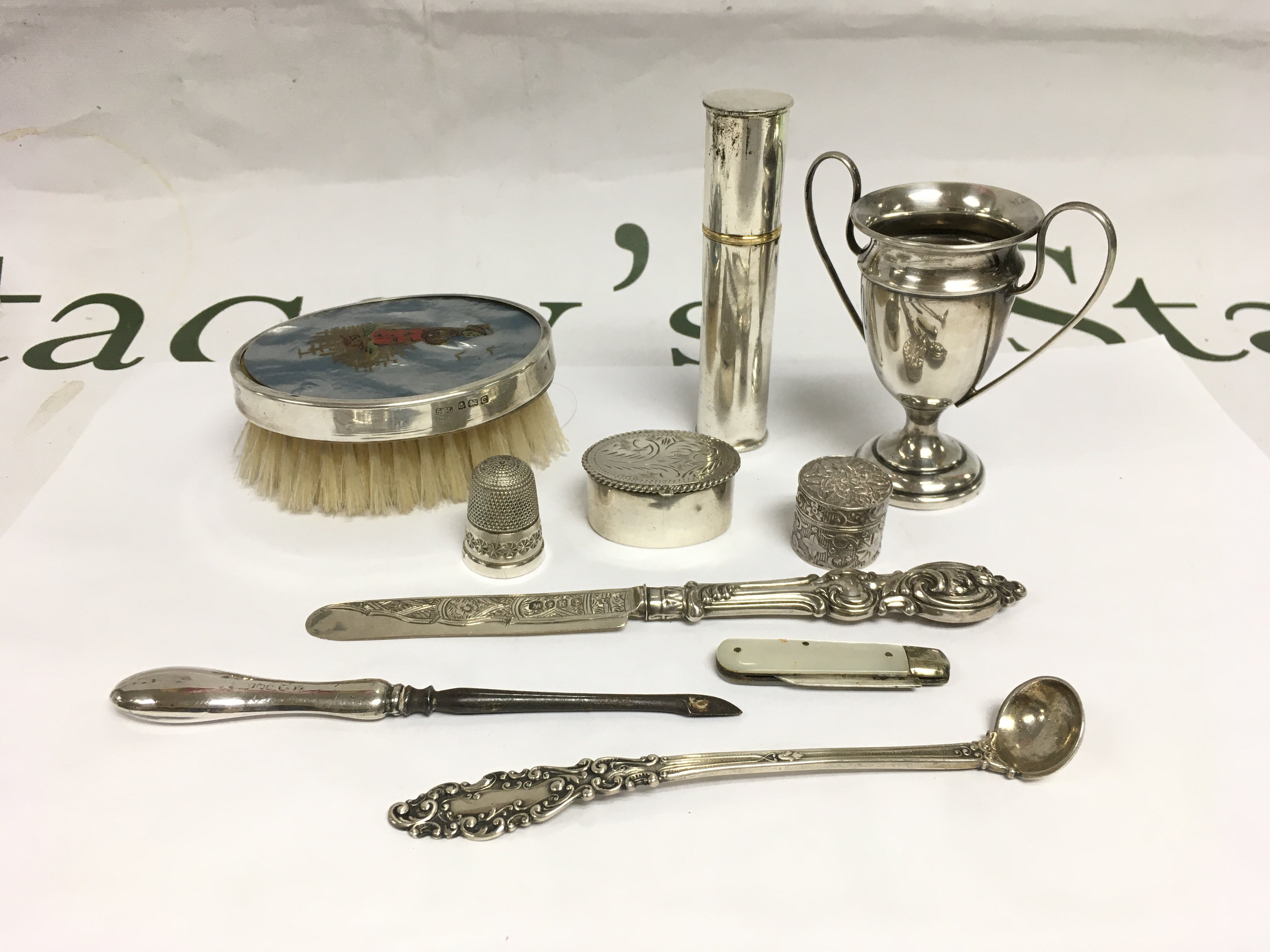 A collection of silver items comprising an atomiser, pill boxes, miniature trophy cup etc. Shipping category B.