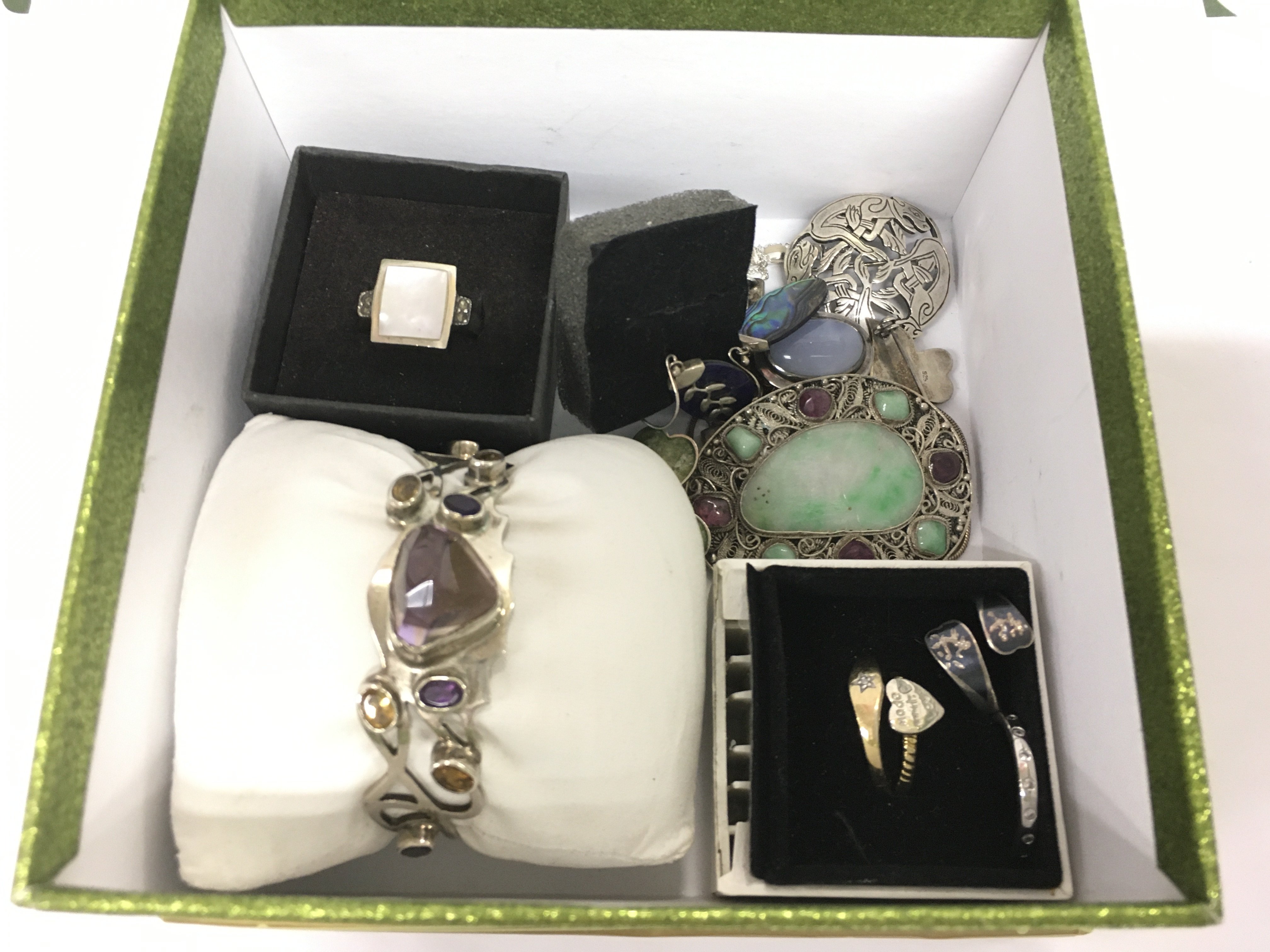 A small collection of silver jewellery items comprising a bangle, rings, brooches etc. Shipping category B.