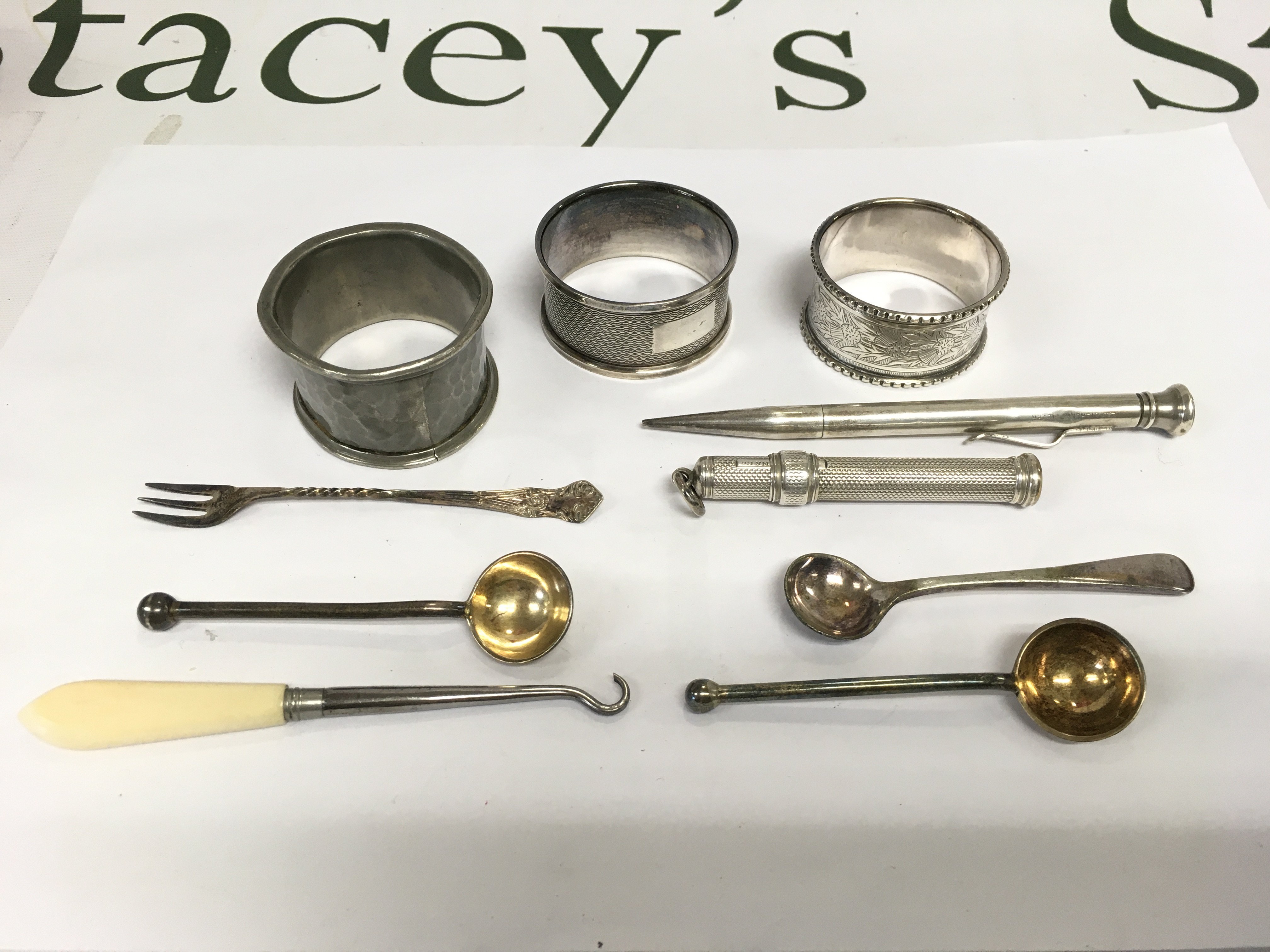 A small collection of silver items comprising propelling pencil, napkin rings, button hook etc. Shipping category B.