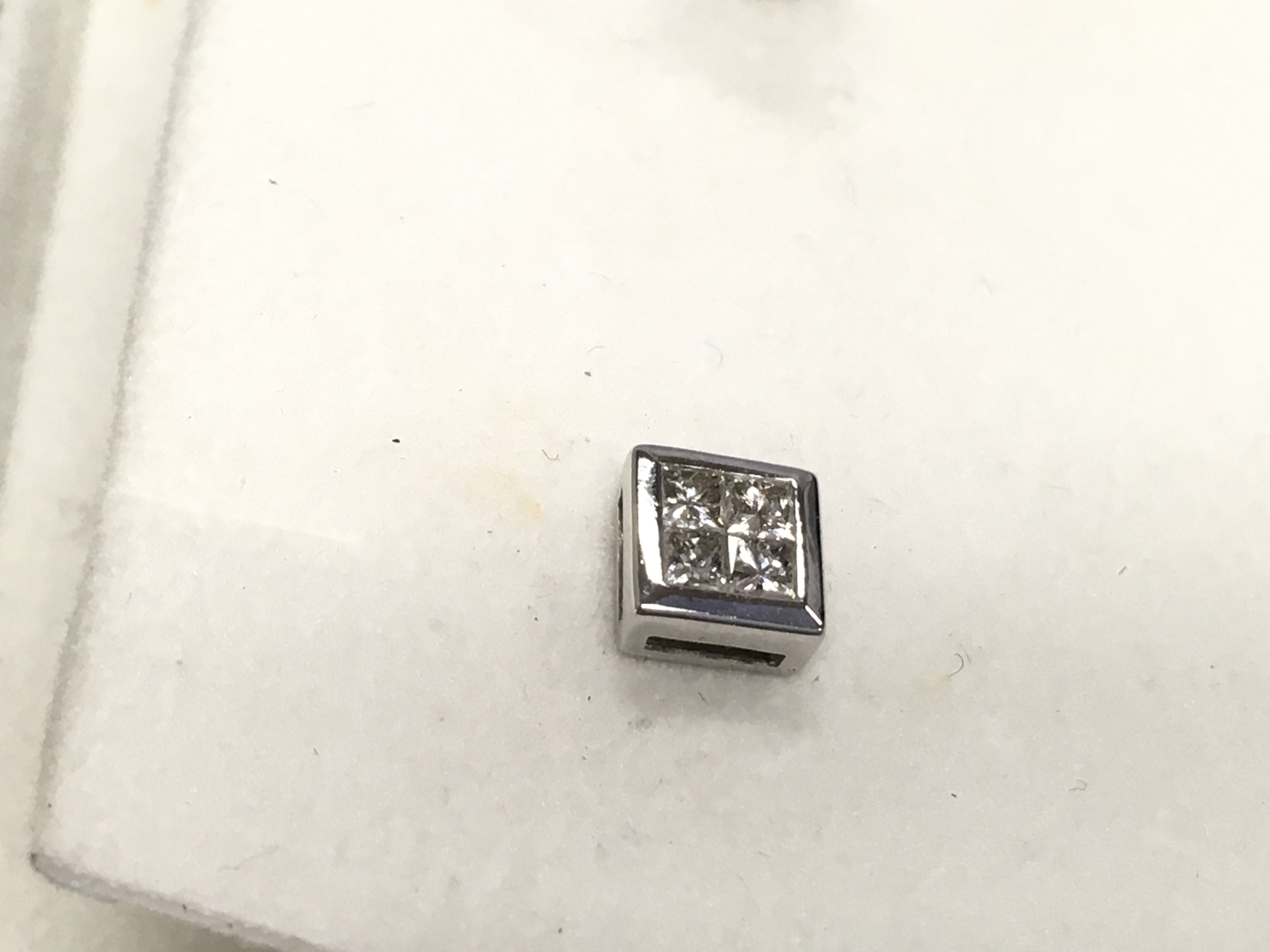 A pair of 9ct white gold illusion Princess cut studs.