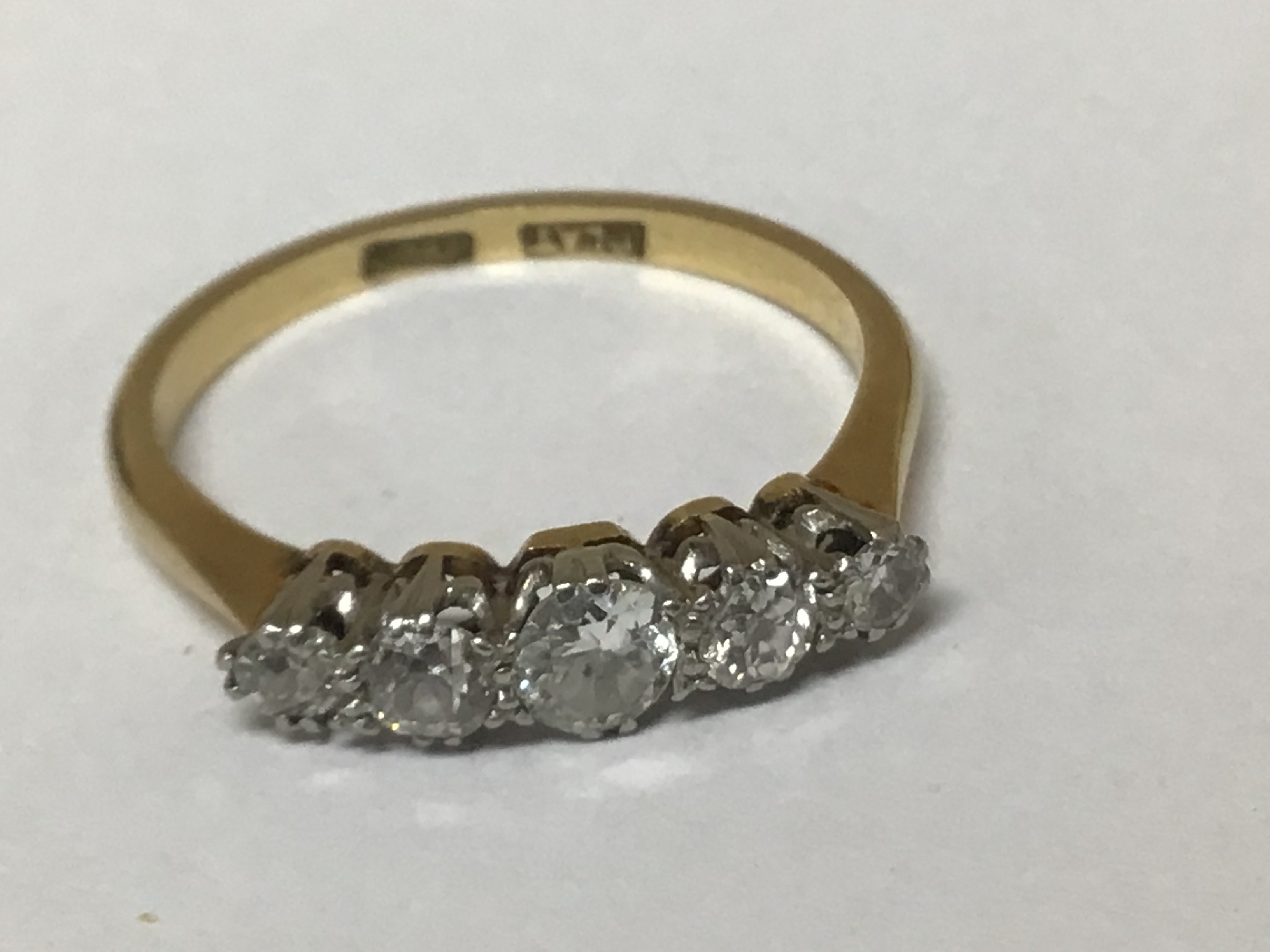 An 18carat gold ring set with a graduating row of five old cut diamonds ring size M weight 2.5g