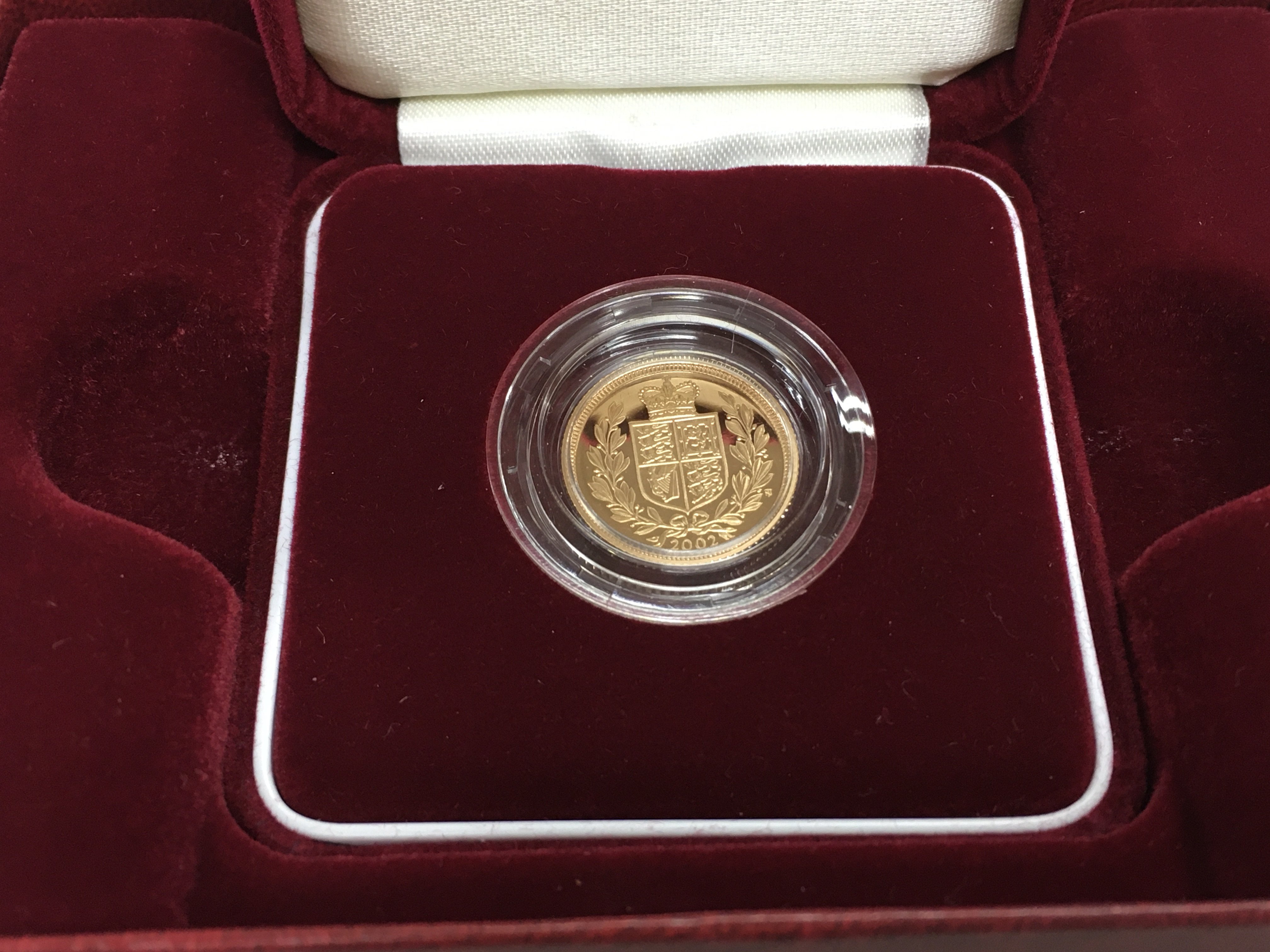 A 2002 proof shield back half sovereign.