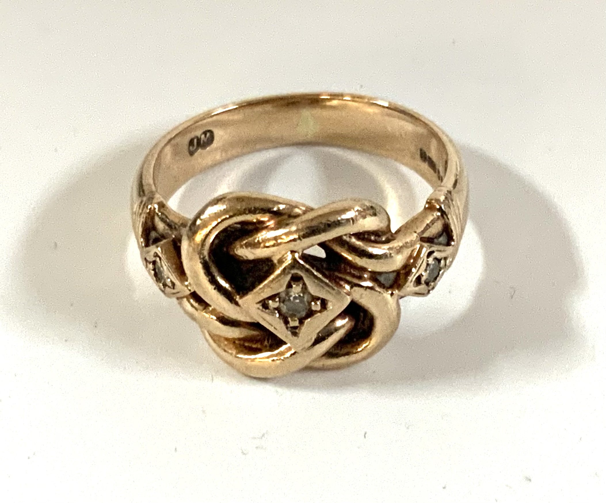 A 9ct gold and diamond set knot ring. Size N. 6.1g (A)
