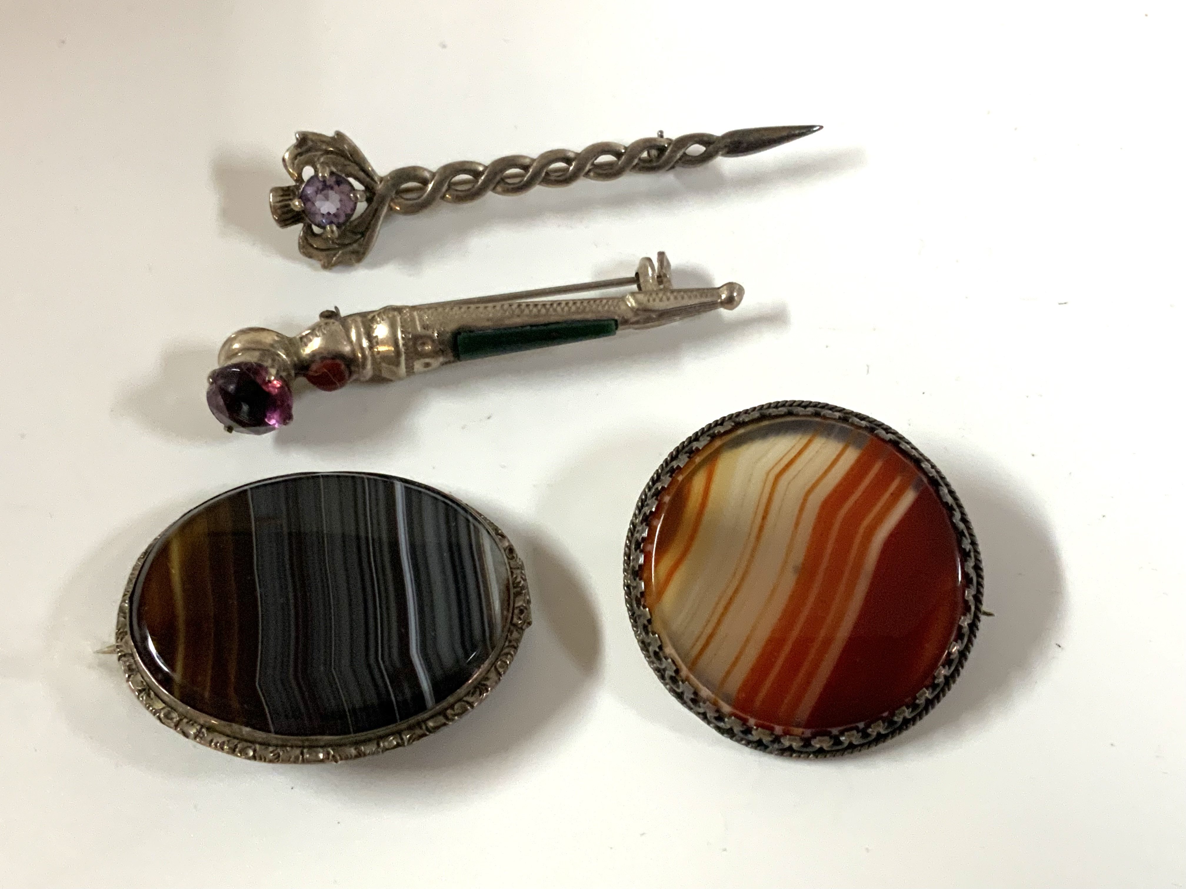 4 sterling silver and agate set brooches. (A)