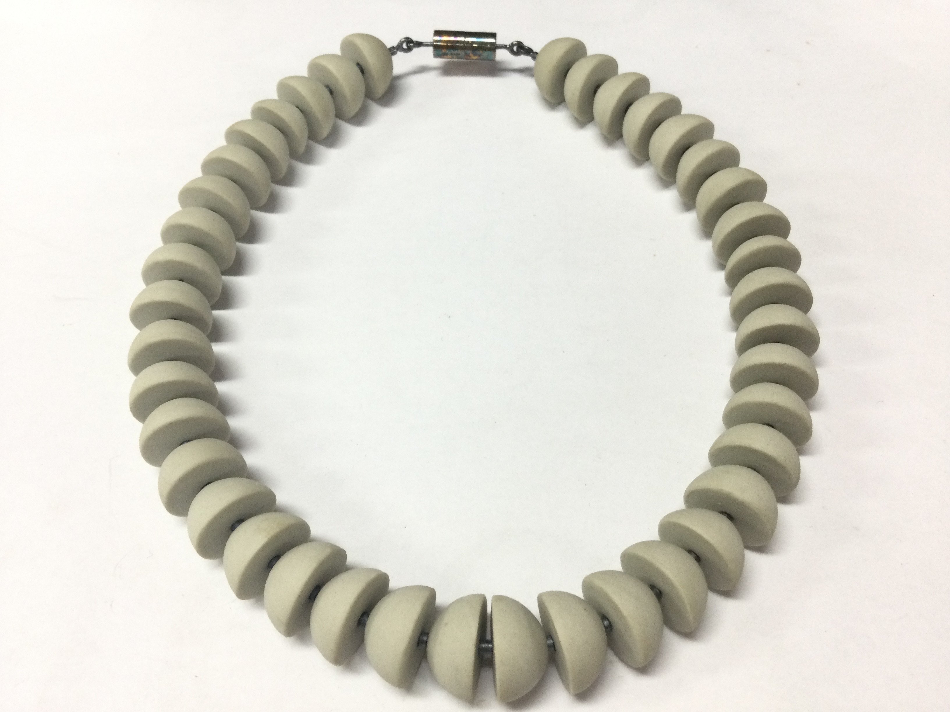 A boxed Wendy Ramshaw (1939-2018) necklace with Wedgwood hand turned beads ,a silver clasp hallmarked maker J.W and signed WR. 13cm wide approximately . Postage category B