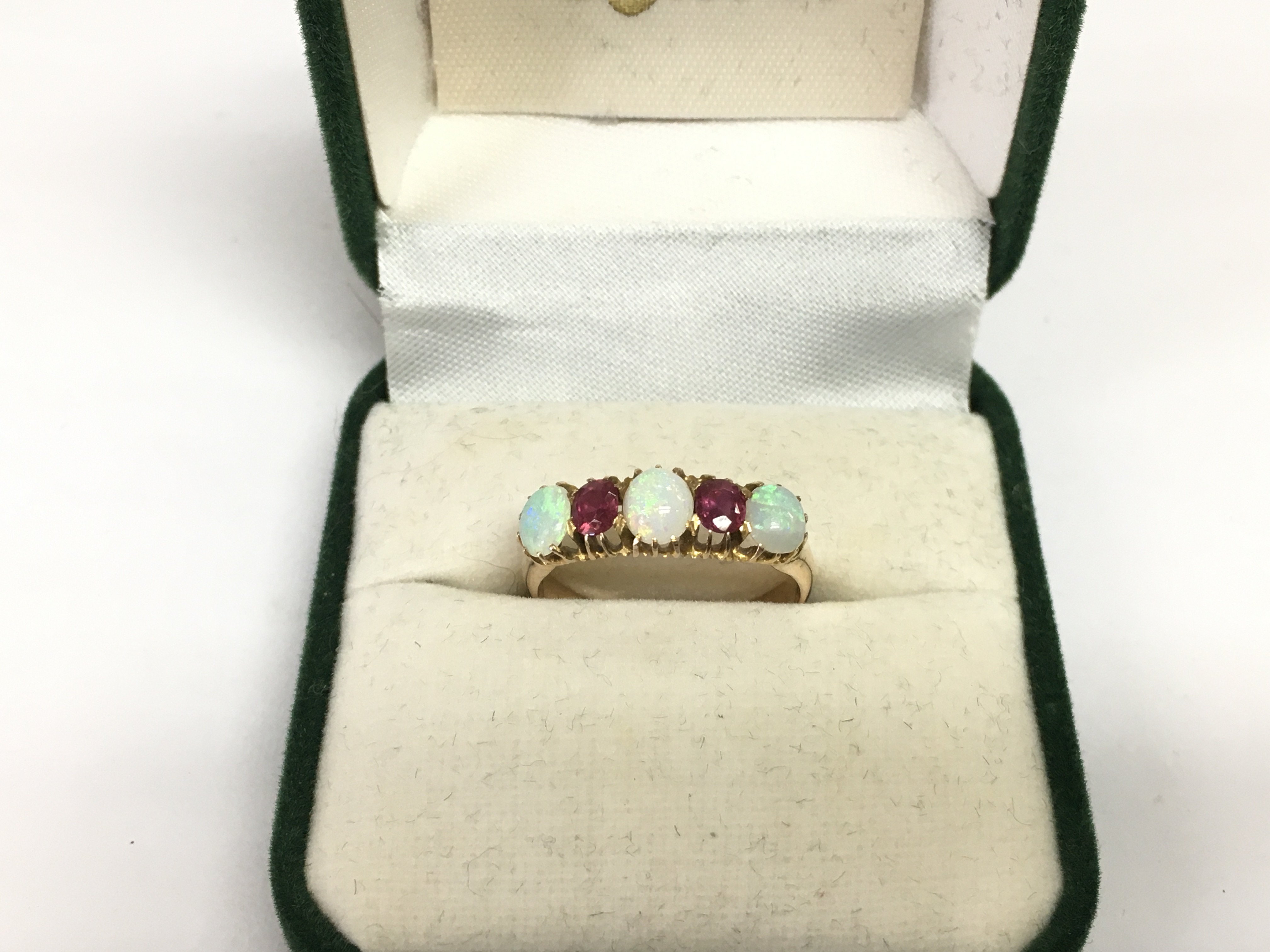 A 15ct gold ring set with opals and rubies, approx 2.8g and approx size N. Shipping category A.