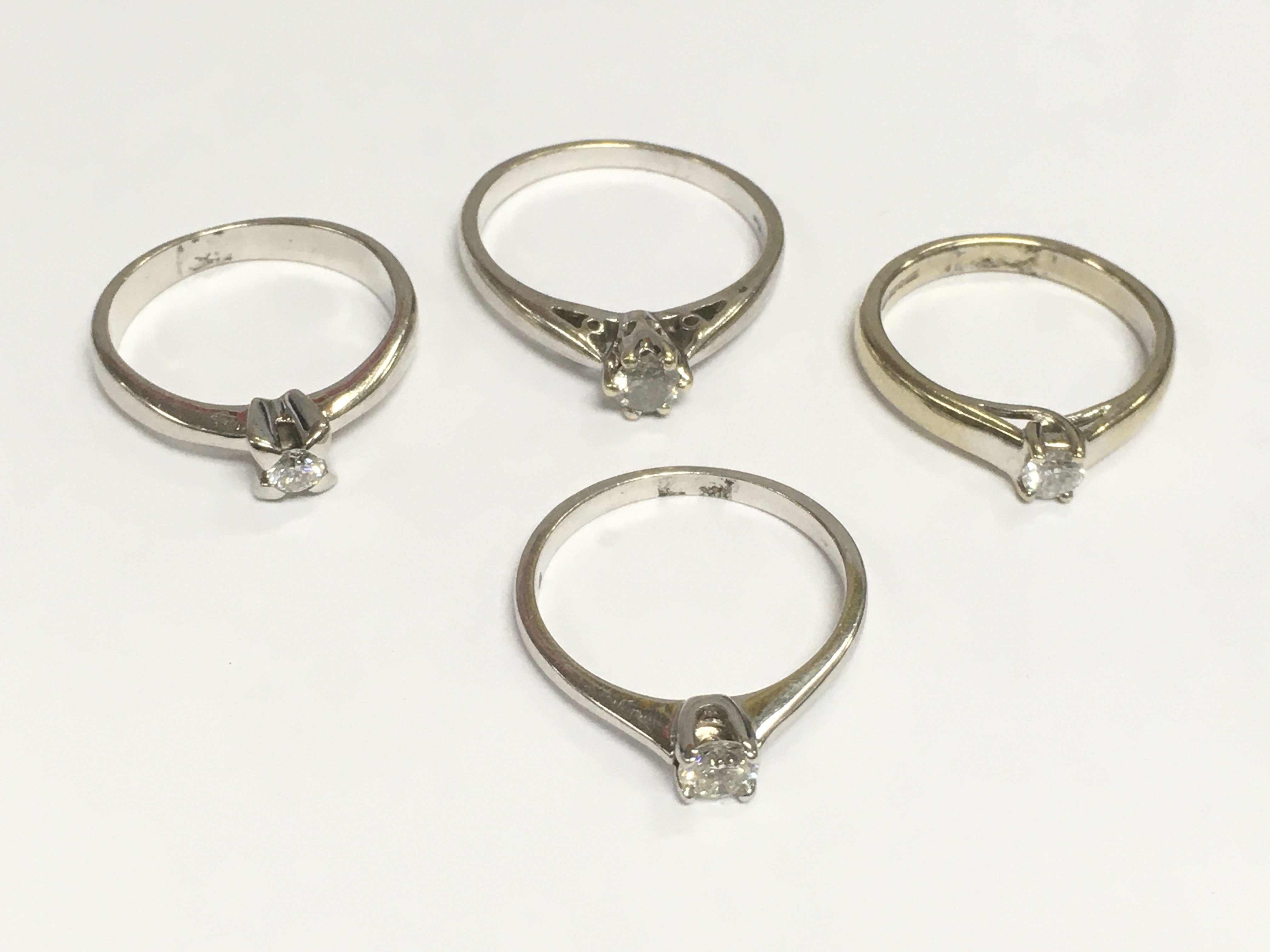 Four 9ct white gold diamond solitaire rings, total approx 10g. Shipping category A.
