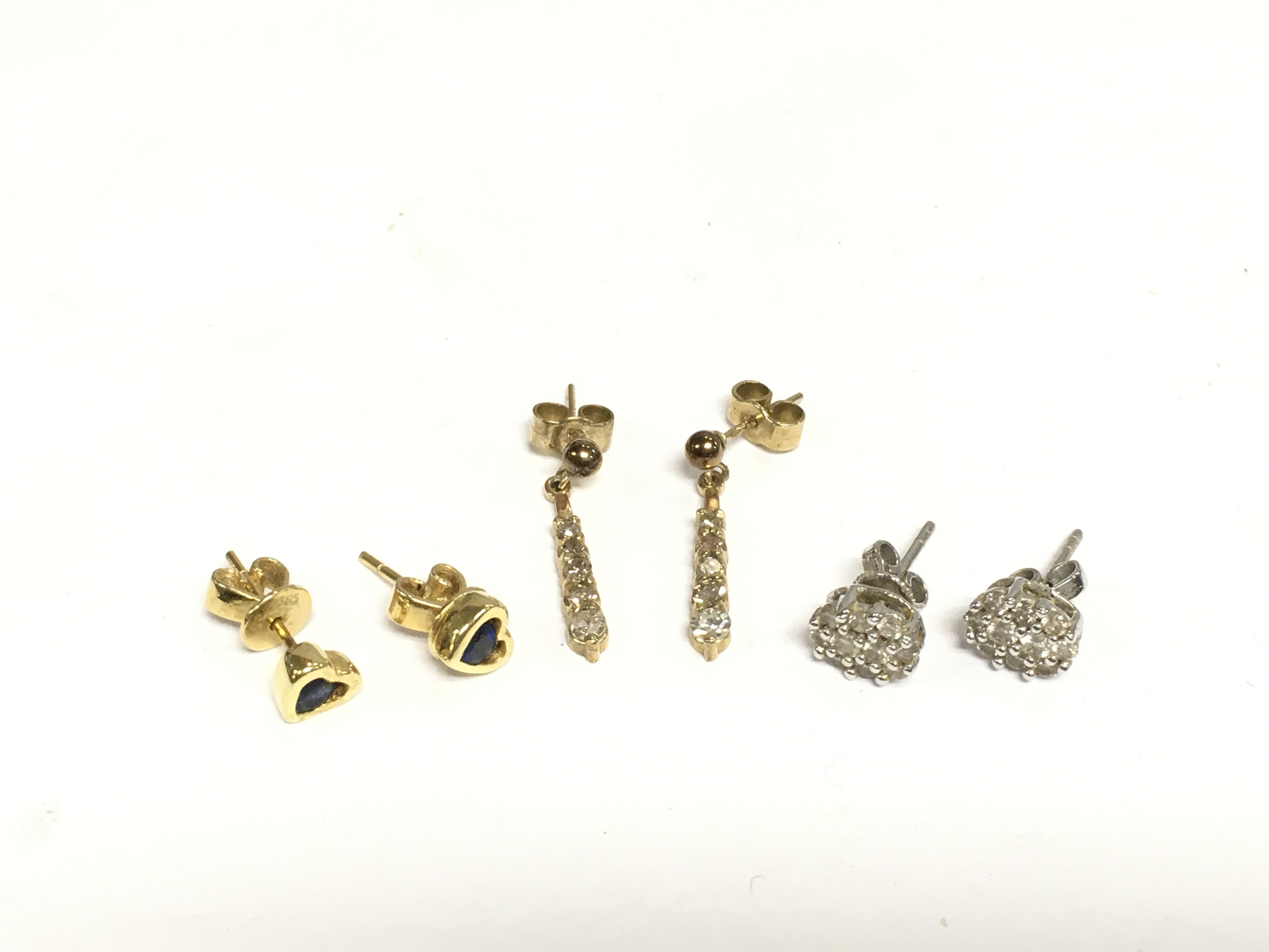Three pairs of earrings including a pair of diamond cluster studs. Shipping category A.