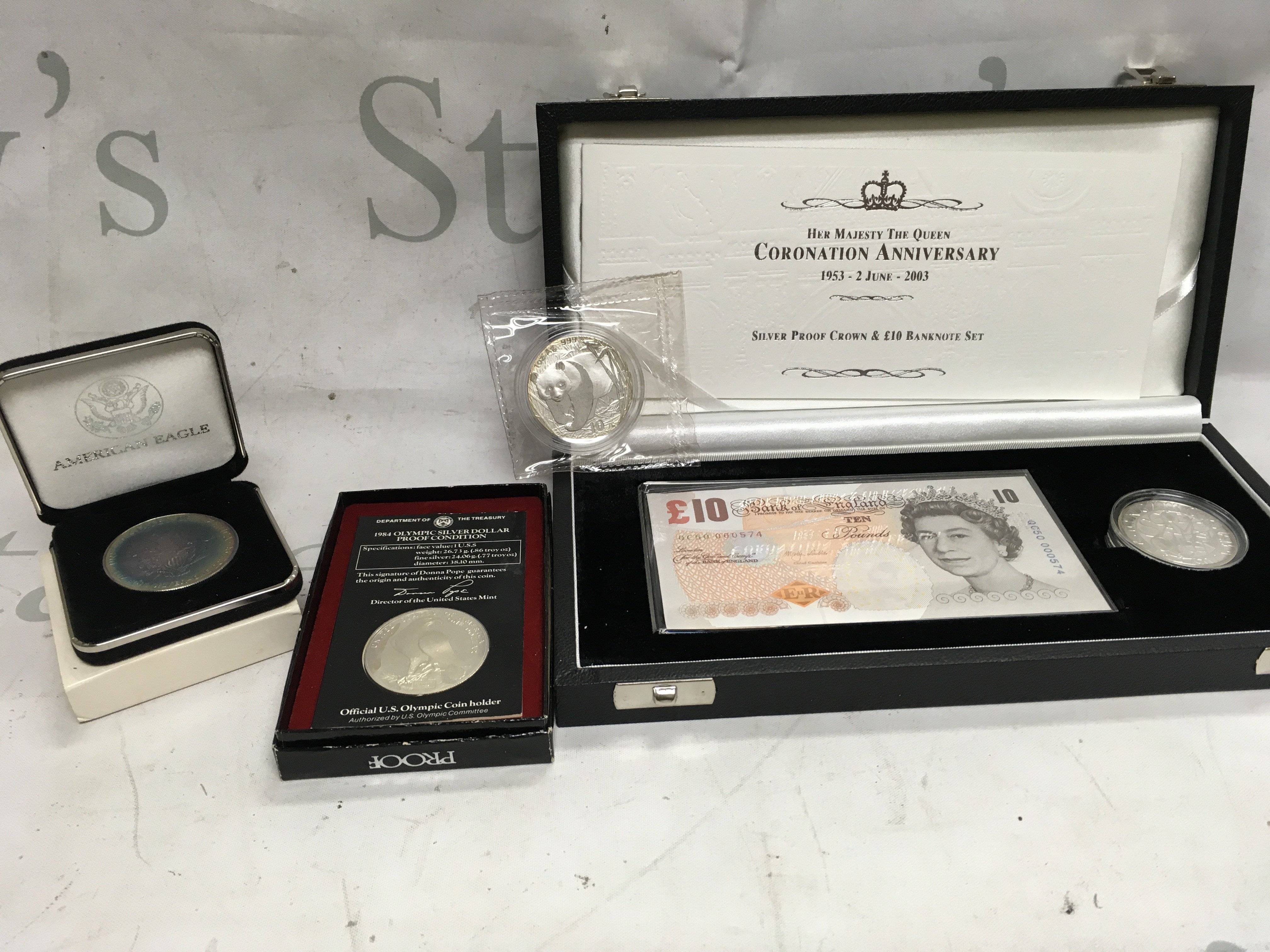 Two American eagle silver proof coins, one Chinese silver 1oz coin and a silver proof crown and &#201326627510 banknote set.