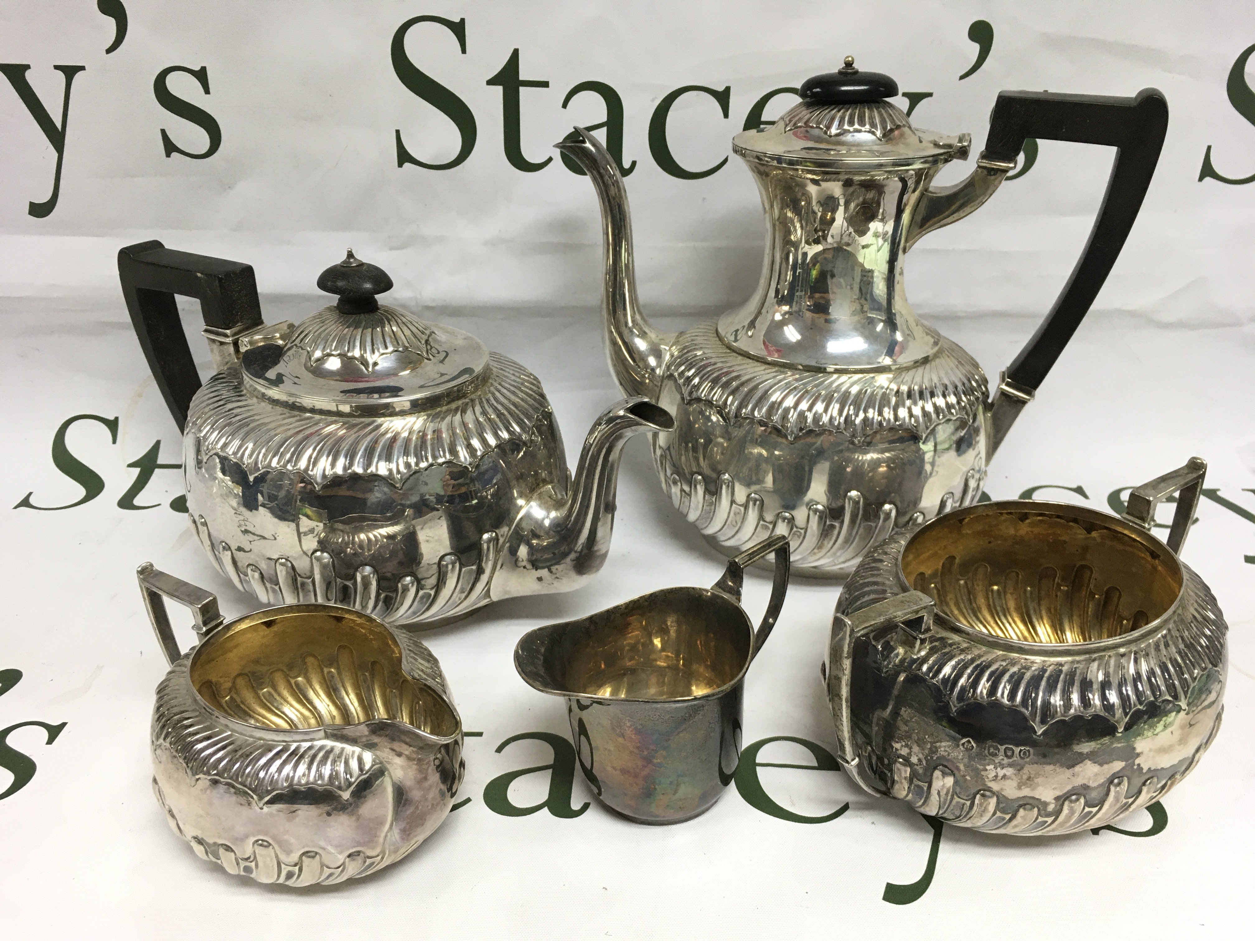 Five silver tea service items comprising four matching but having different hallmarks. Shipping category B.