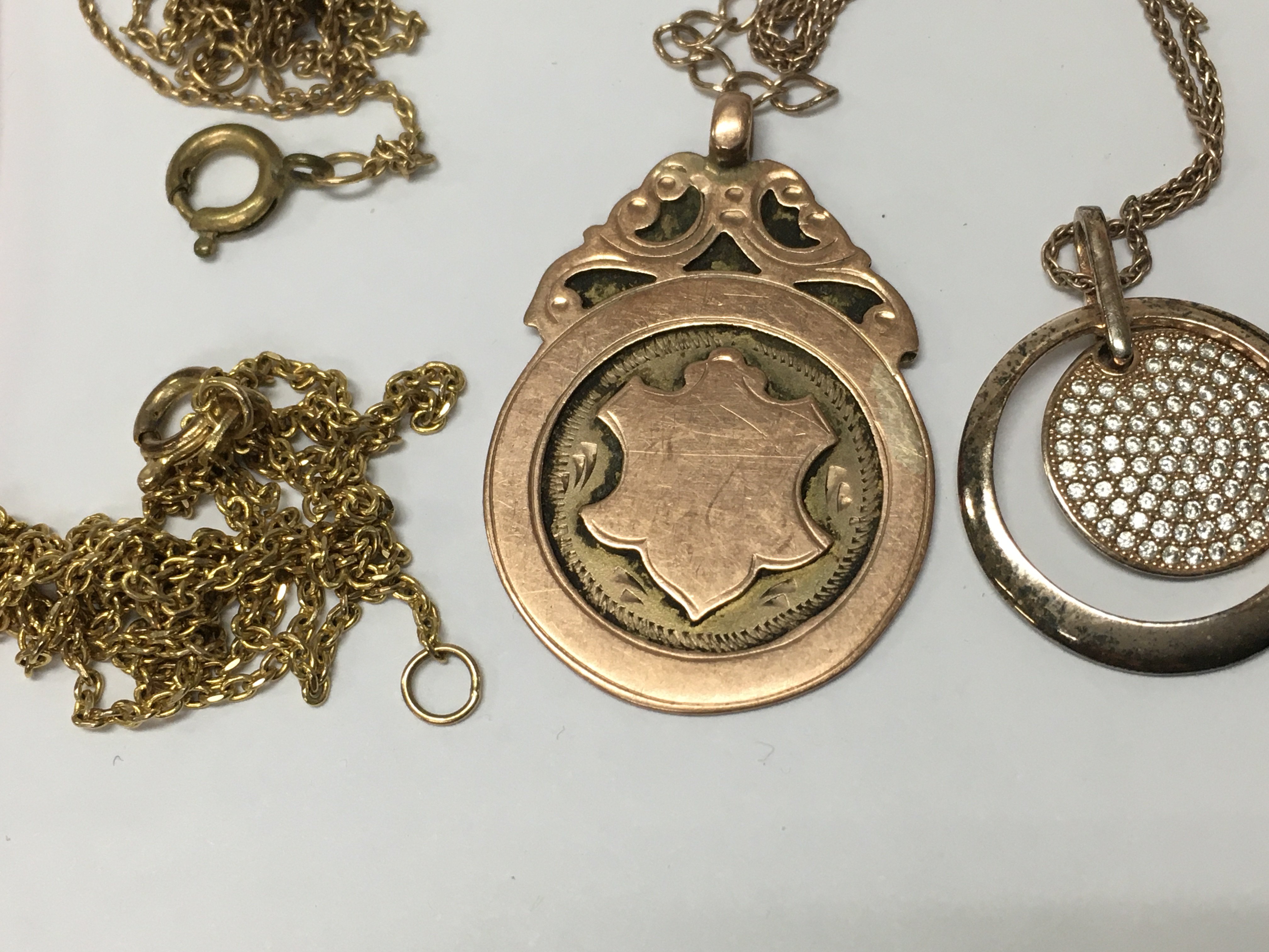 A 9 ct gold pendant (4.5grams ) two gold tone chains and a silver chain and pendant.