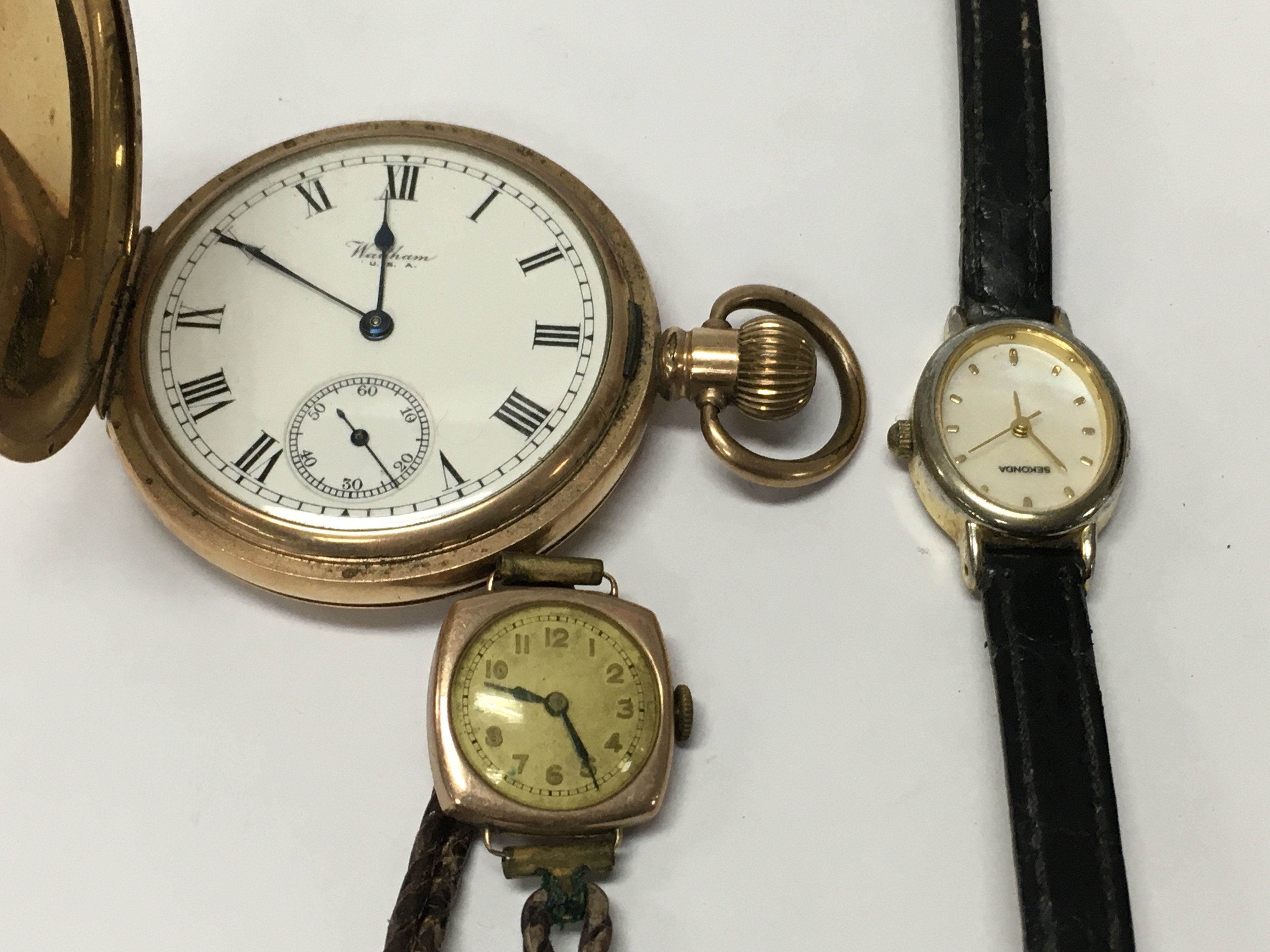 A gold case pocket watch together with to wrist watches .