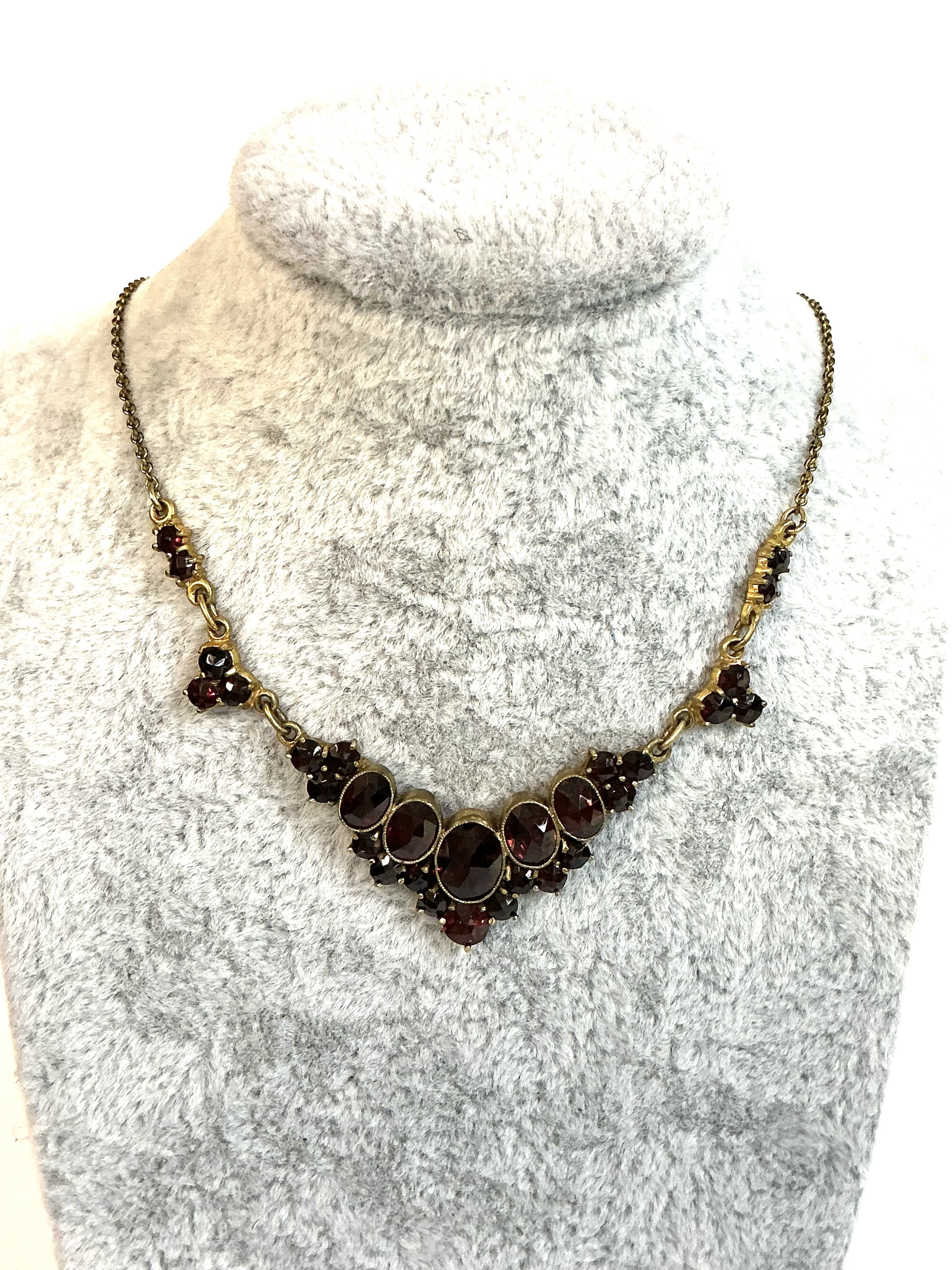 A vintage yellow metal and garnet necklace.