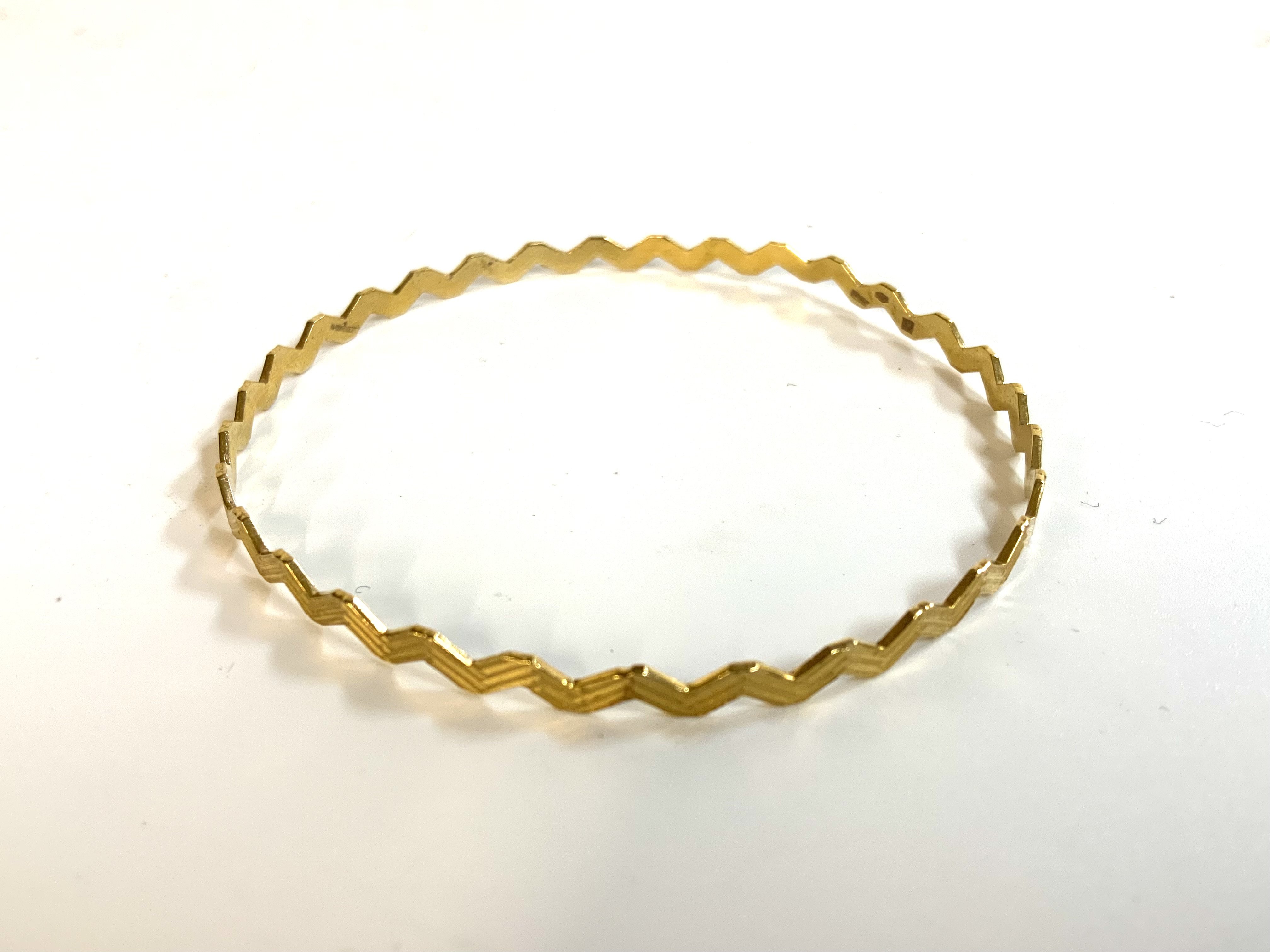 A 9ct gold ZigZag bangle. (A)