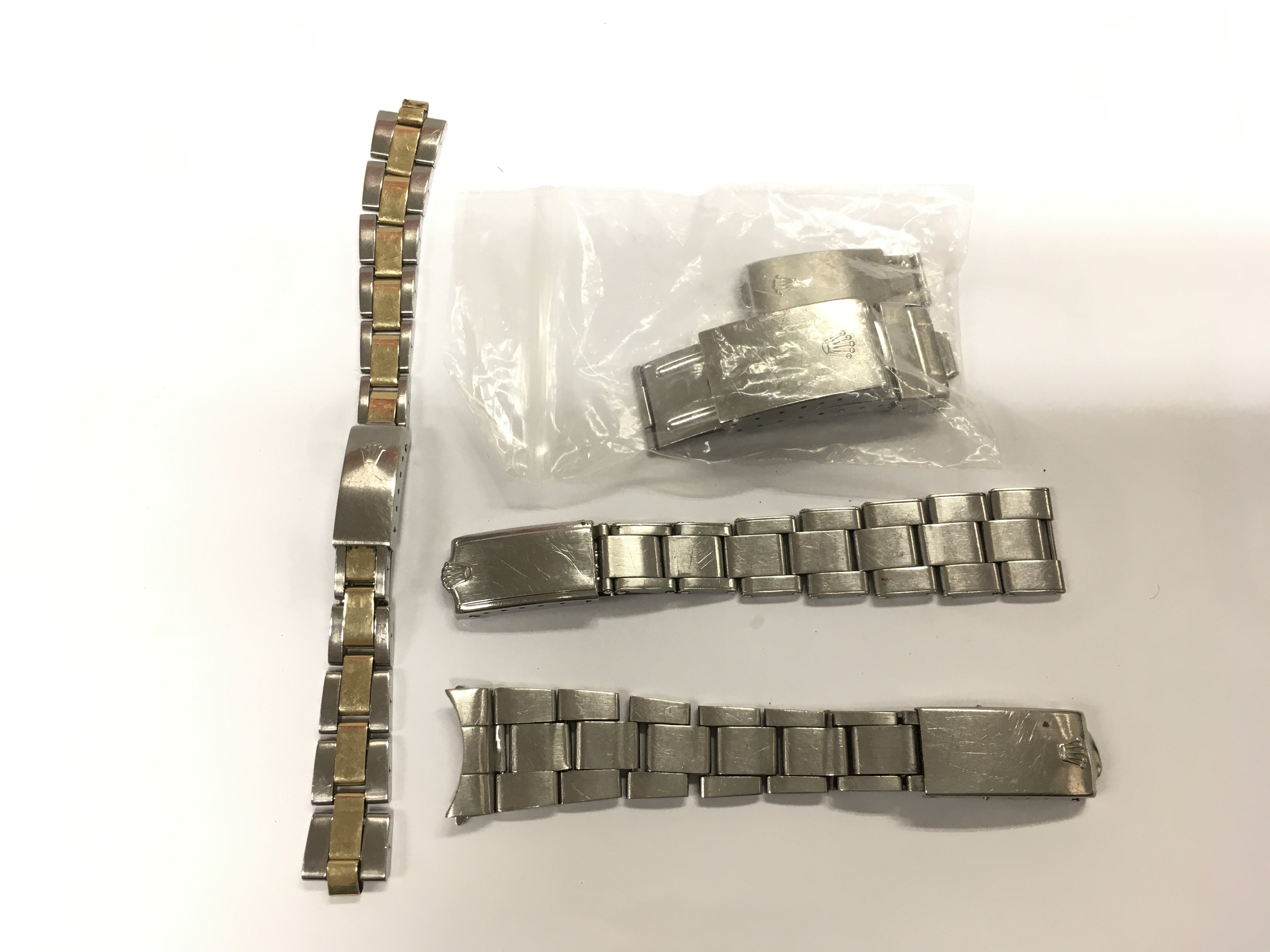 Five steel watch clasps and chains including Rolex examples. Shipping category A.