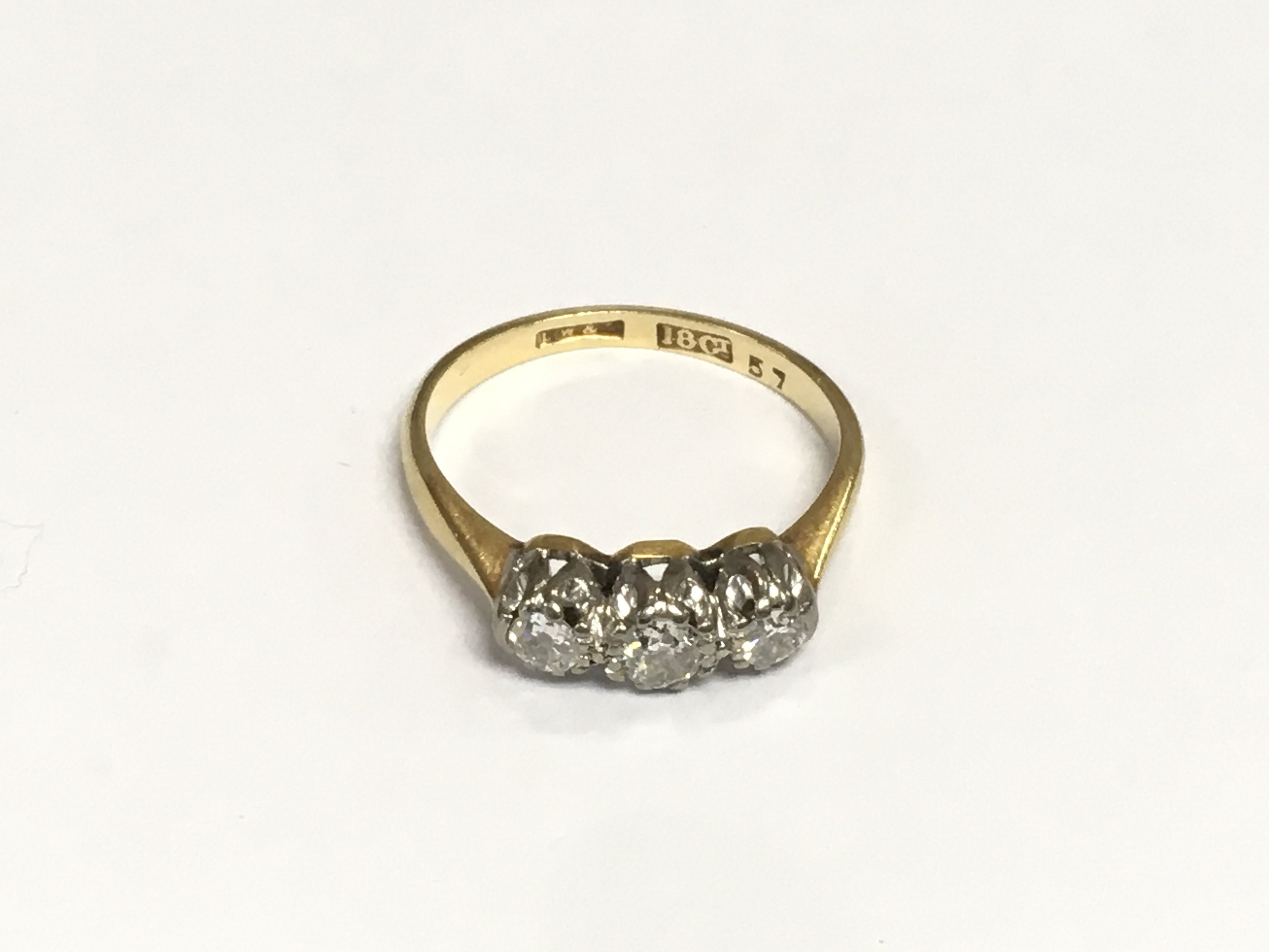 An 18ct gold ring set with three old cut diamonds, approx 2.6g and approx size I-J. Shipping category A.