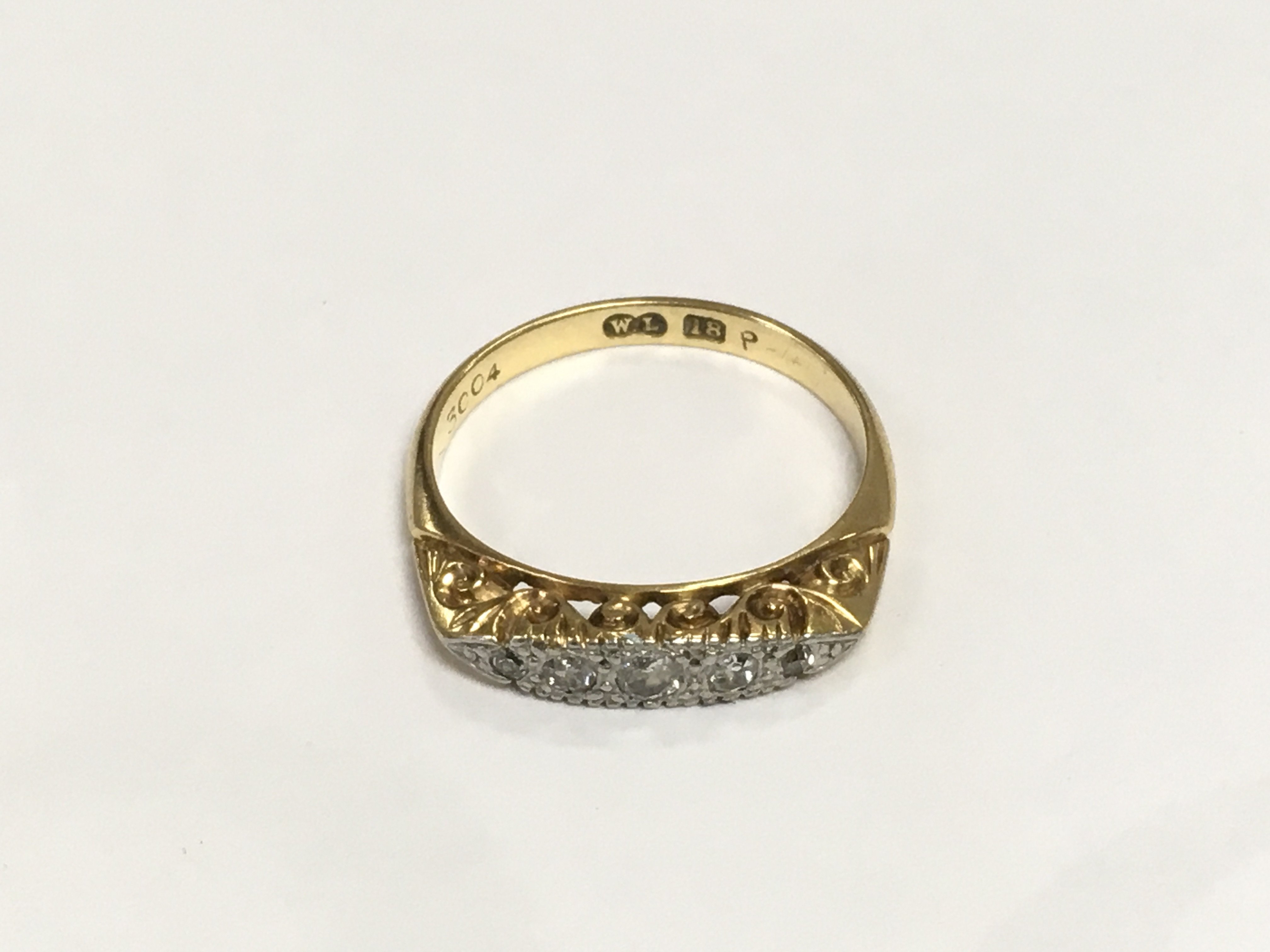 An 18ct gold ring set with five small diamonds, approx 3g and approx size L-M. Shipping category A.