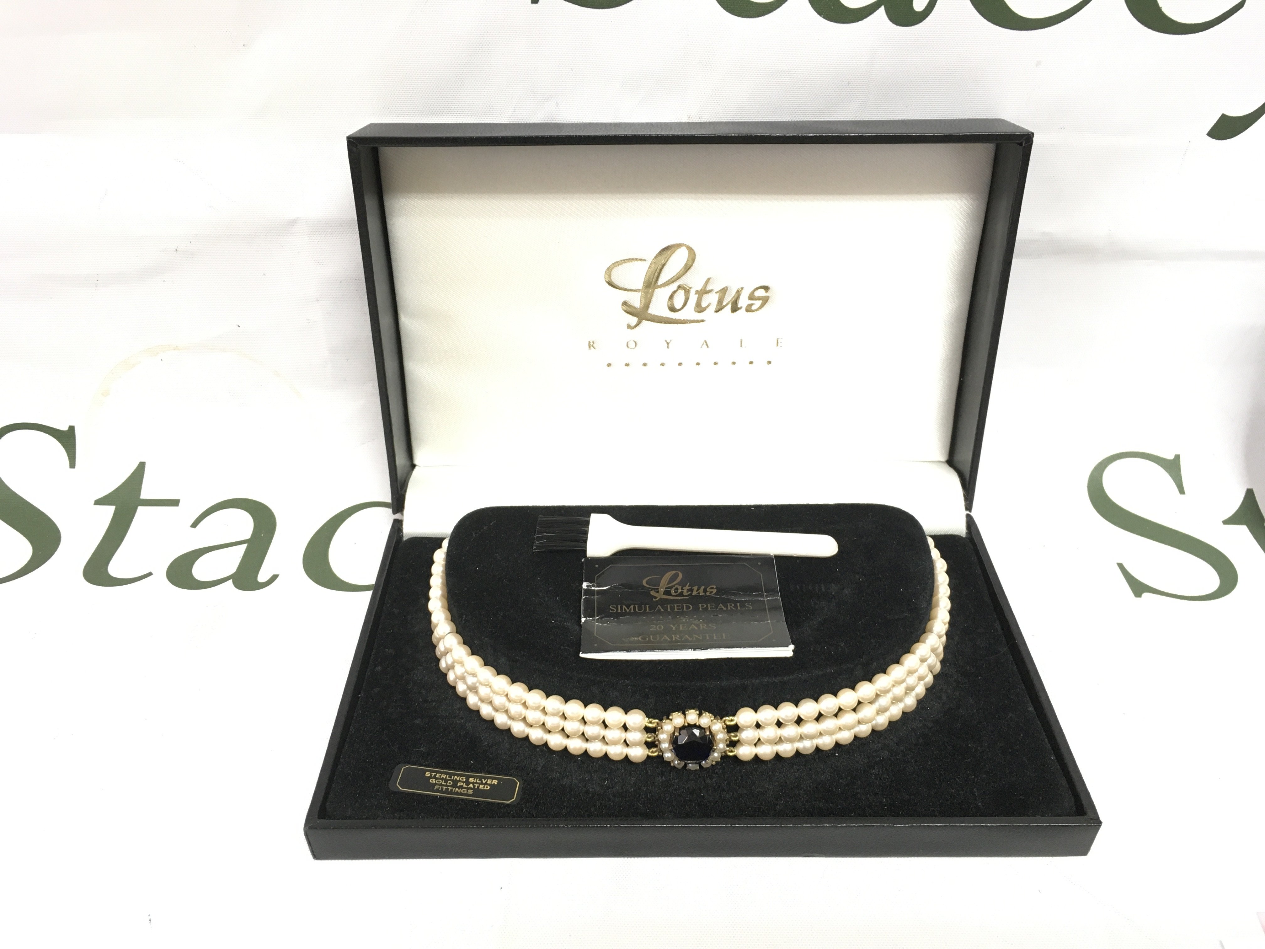 A boxed Lotus simulated pearl necklace, Shipping category B.