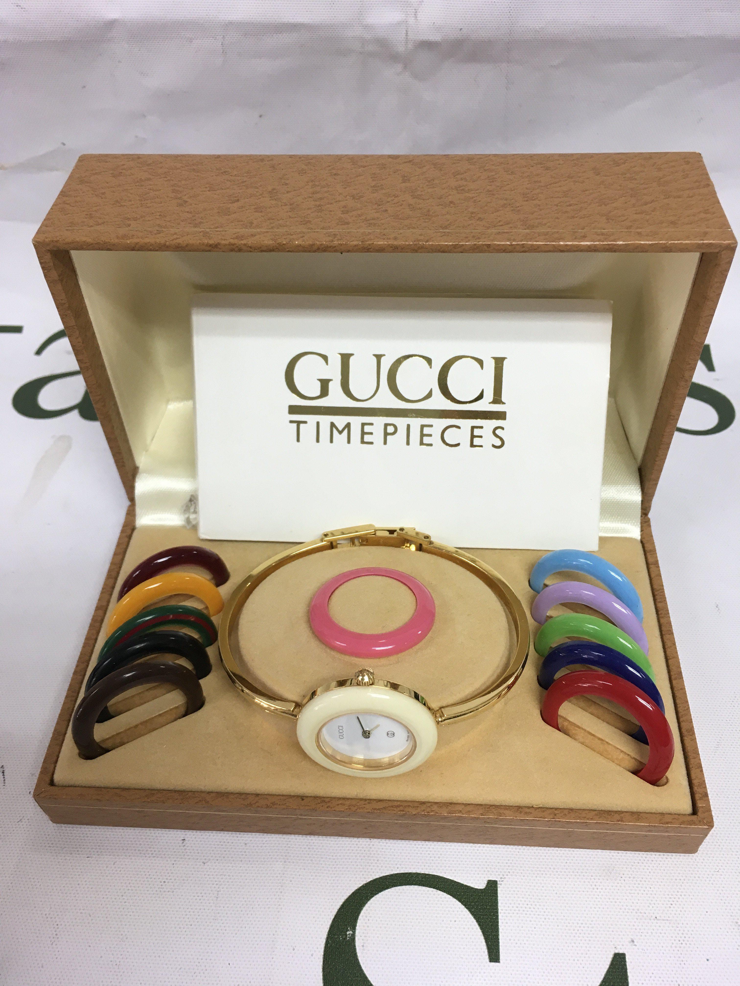 A Gucci ladies watch in a fitted box with interchangeable outer bezel. Shipping category B.