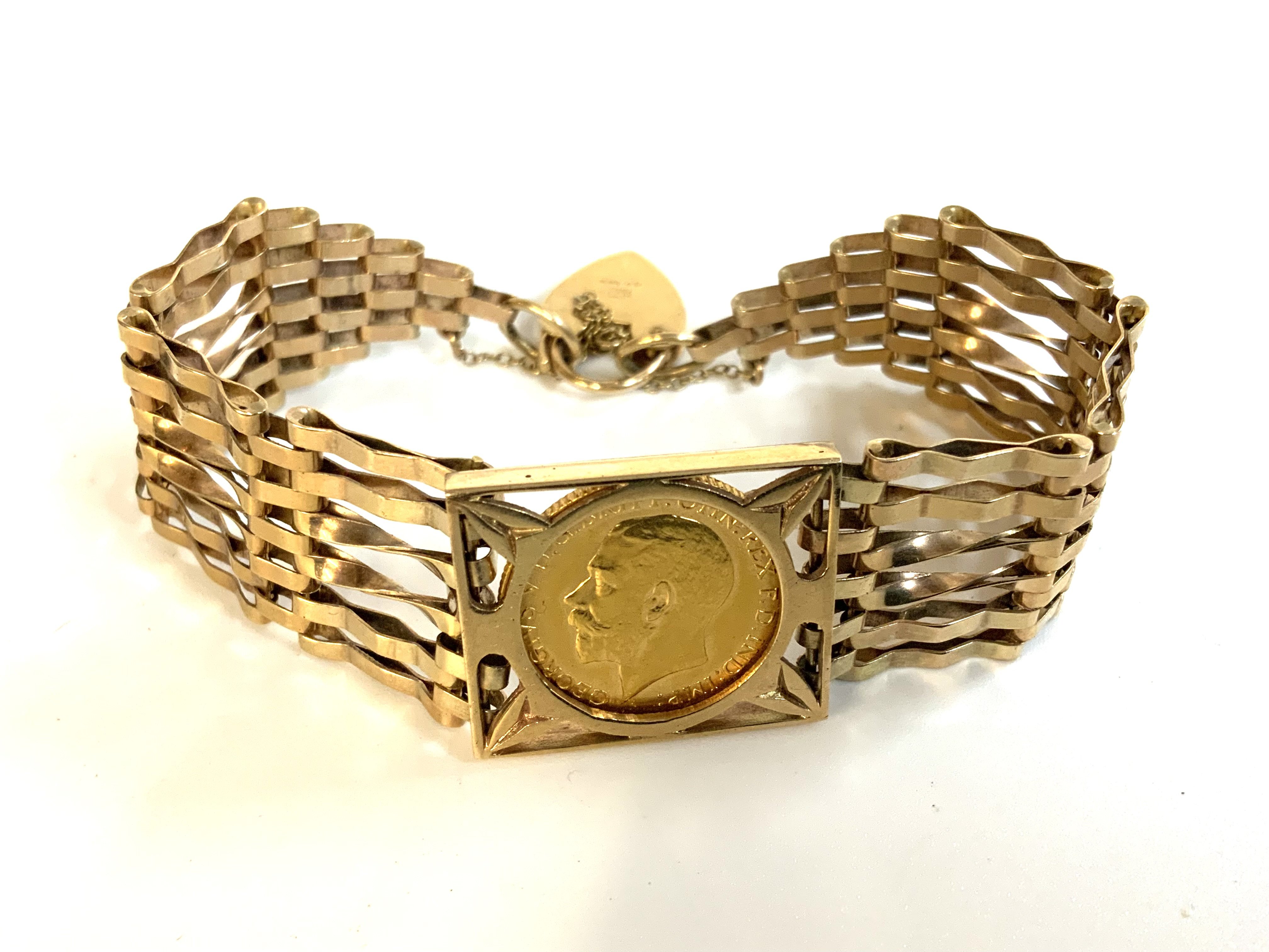 A 9ct gold gate bracelet inset with a 1911 George V half sovereign in coin mount. (A)