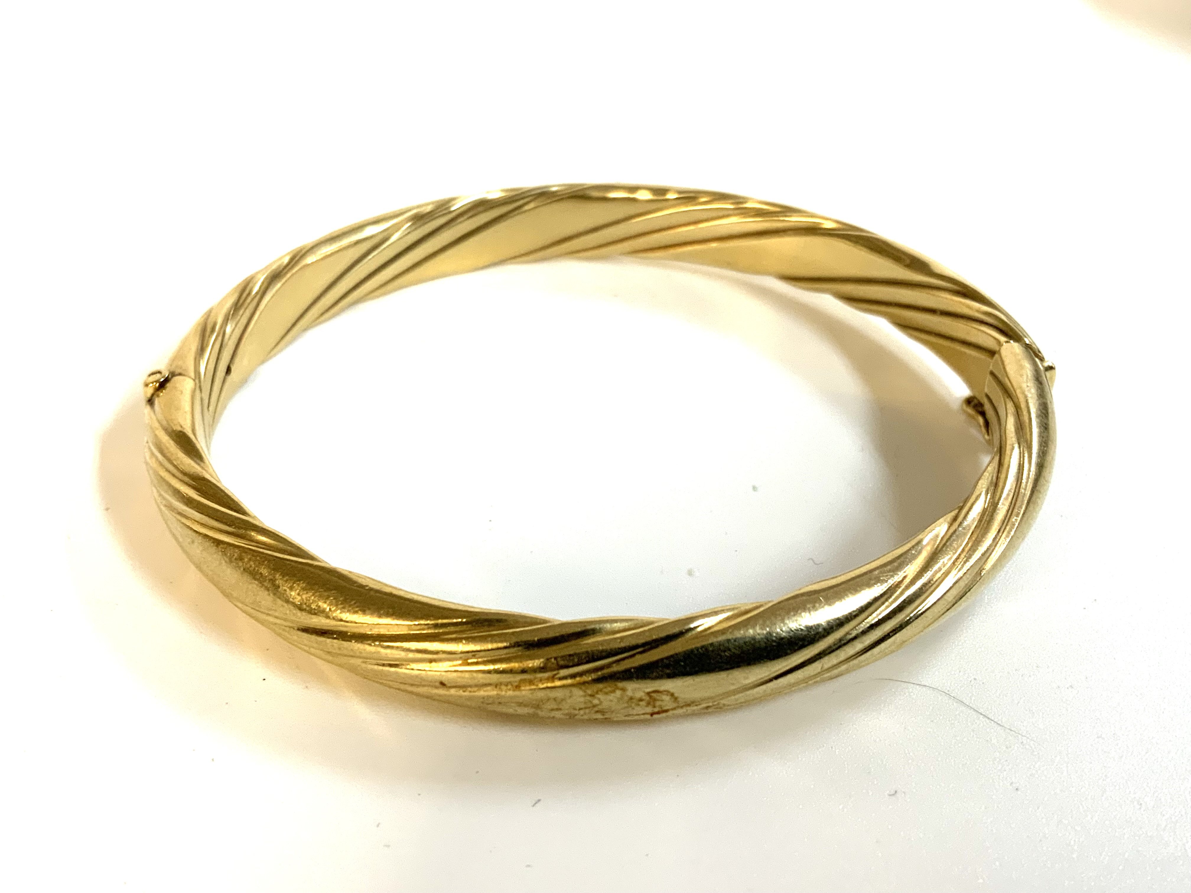 A 9ct gold twist design bangle, metal core. total weight 23.5g.