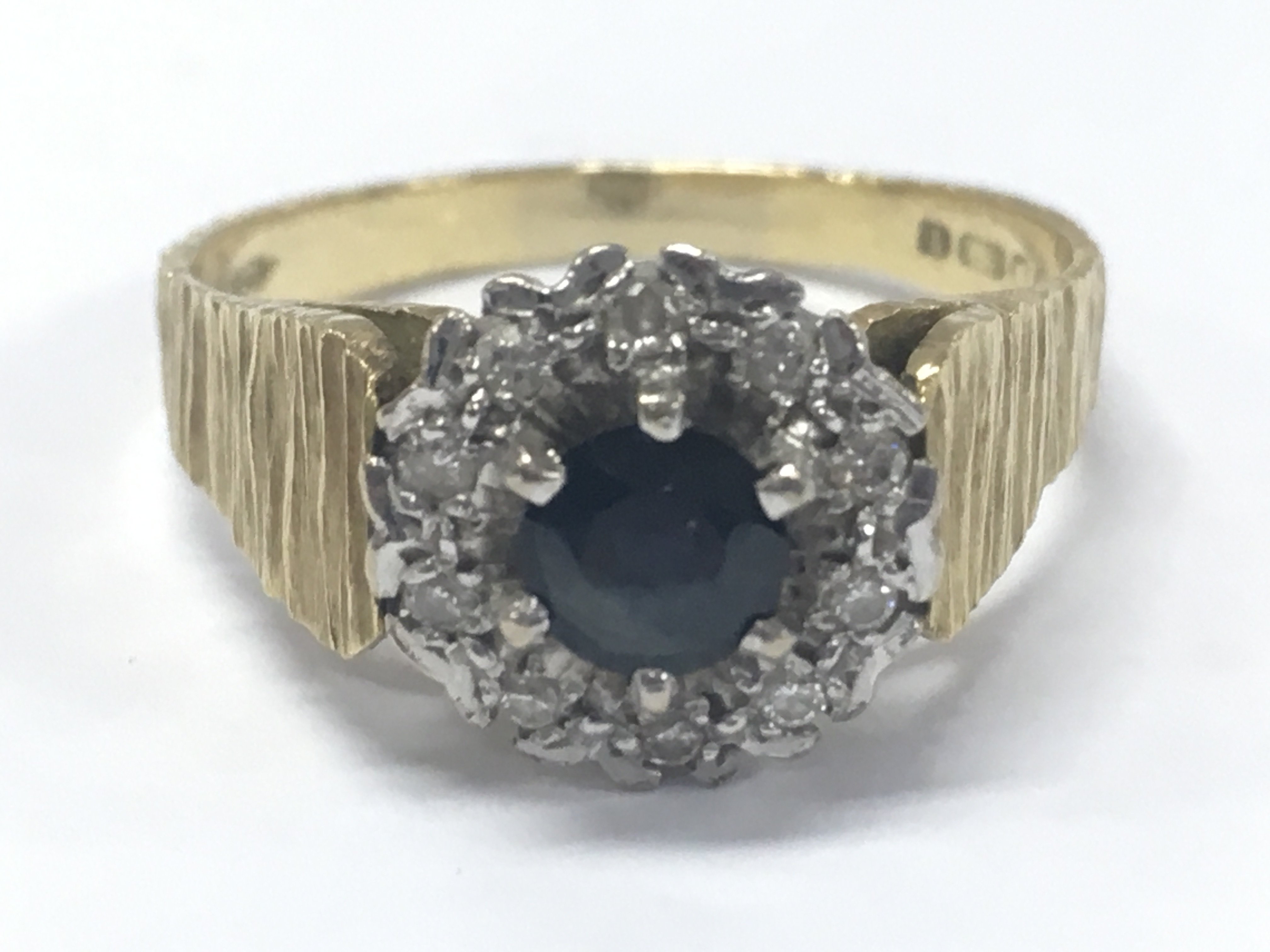 An 18ct gold sapphire and diamond cluster ring . 5.7g total weight. Size R/S. Postage category A