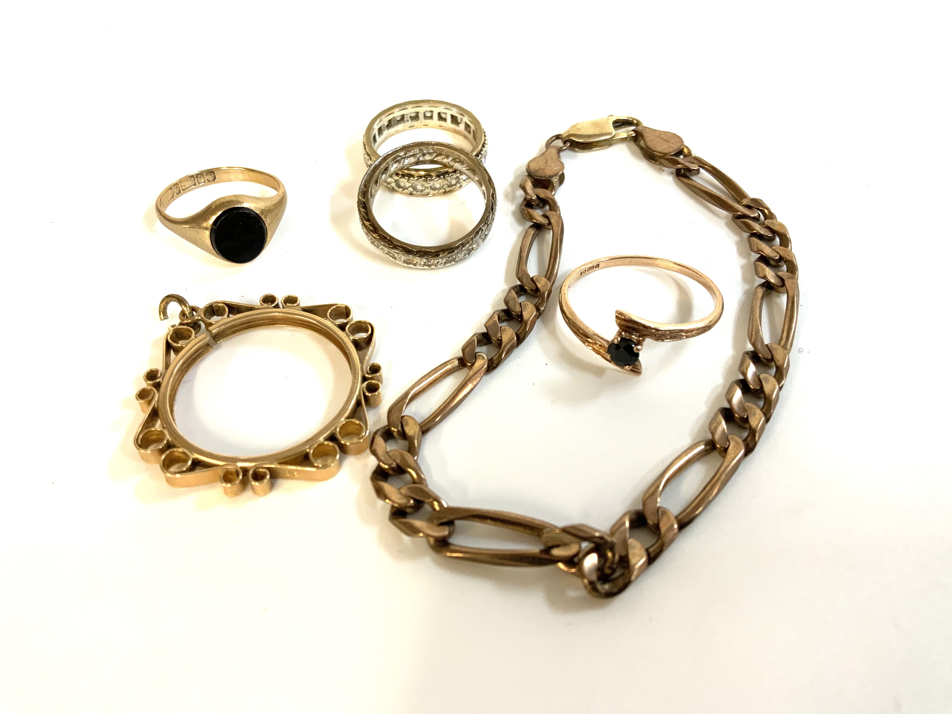 A small collection of 9ct gold jewellery to include a 9ct coin mount, 2 stone set eternity rings, gold bracelet and 2 stone set rings.